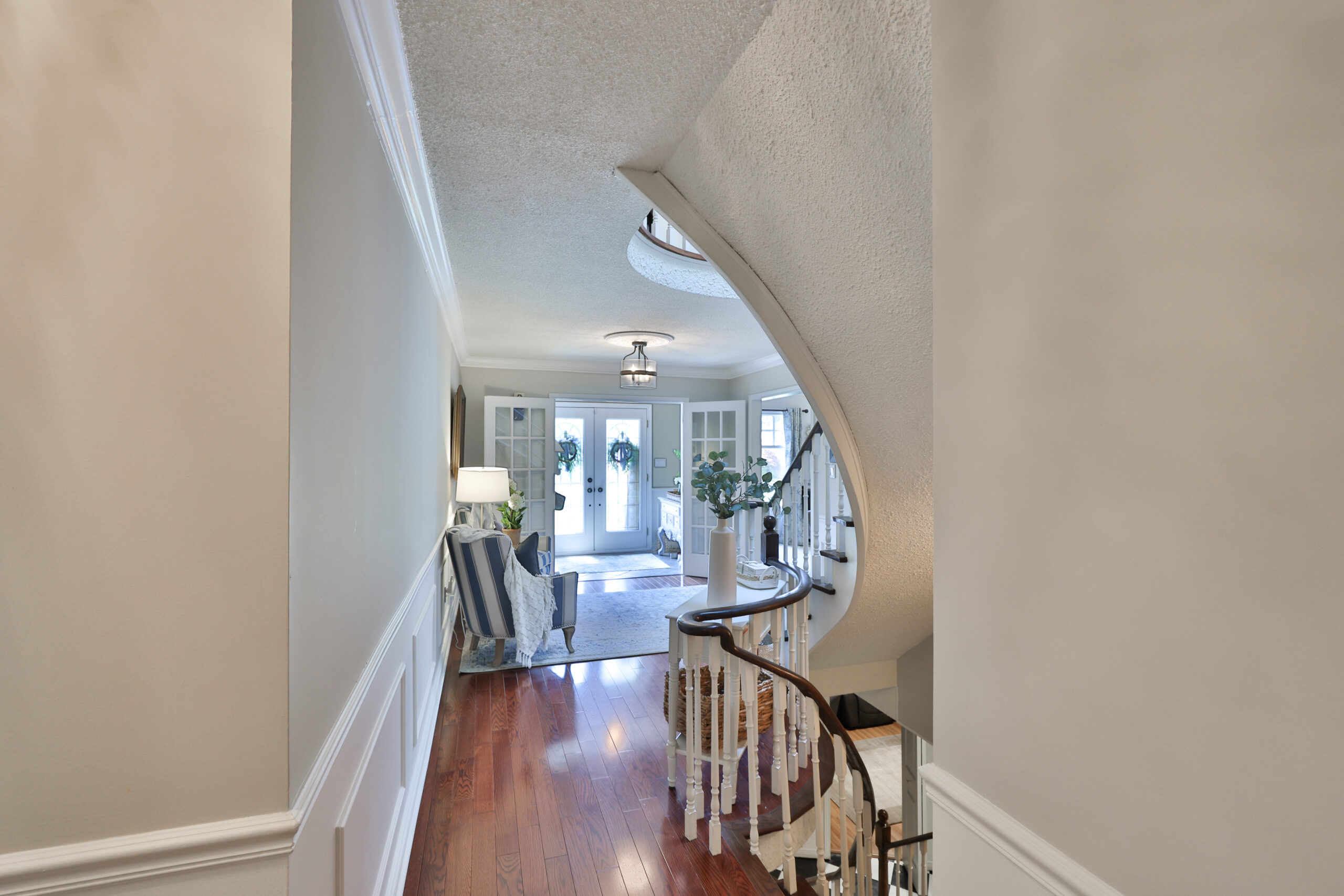 Elegant foyer with curved staircase and hardwood flooring