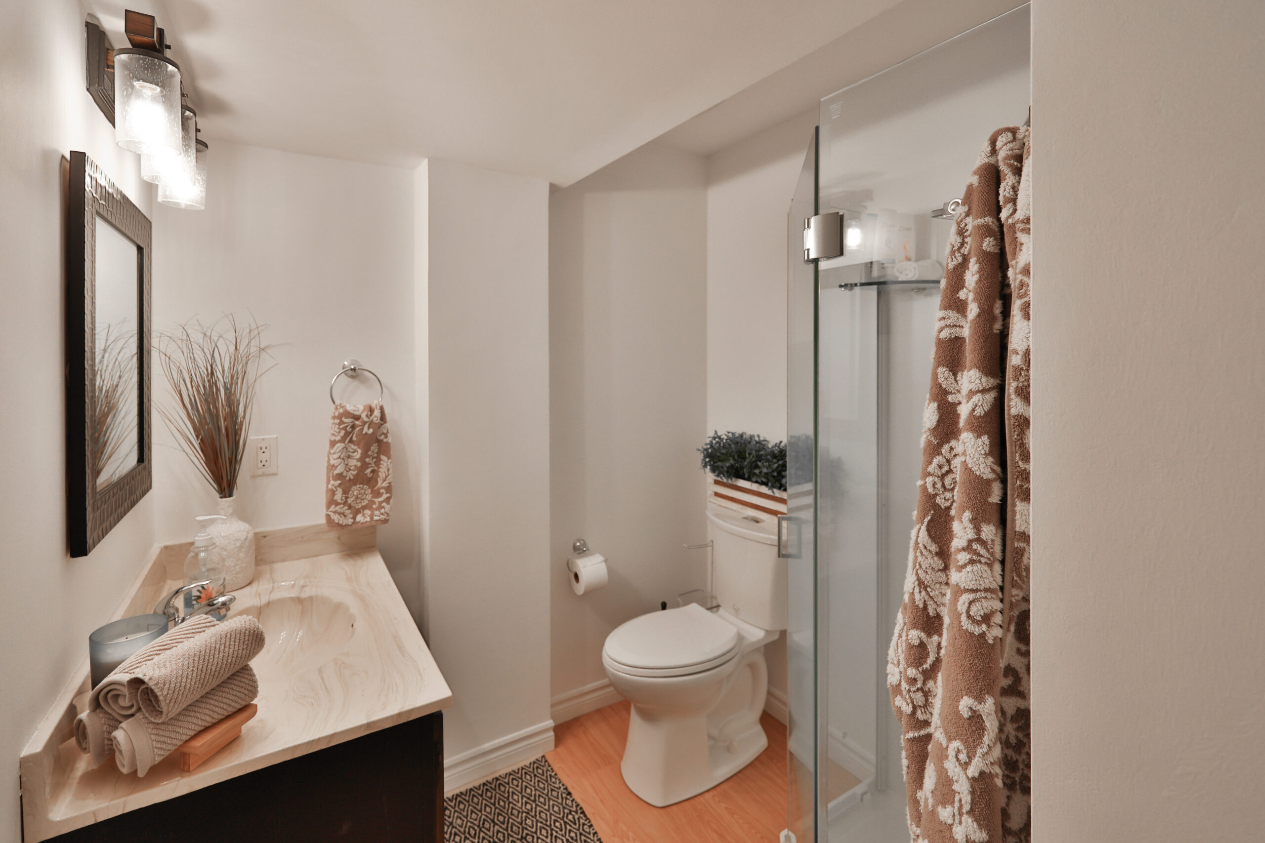 Modern bathroom featuring a shower, toilet, and decorative towels