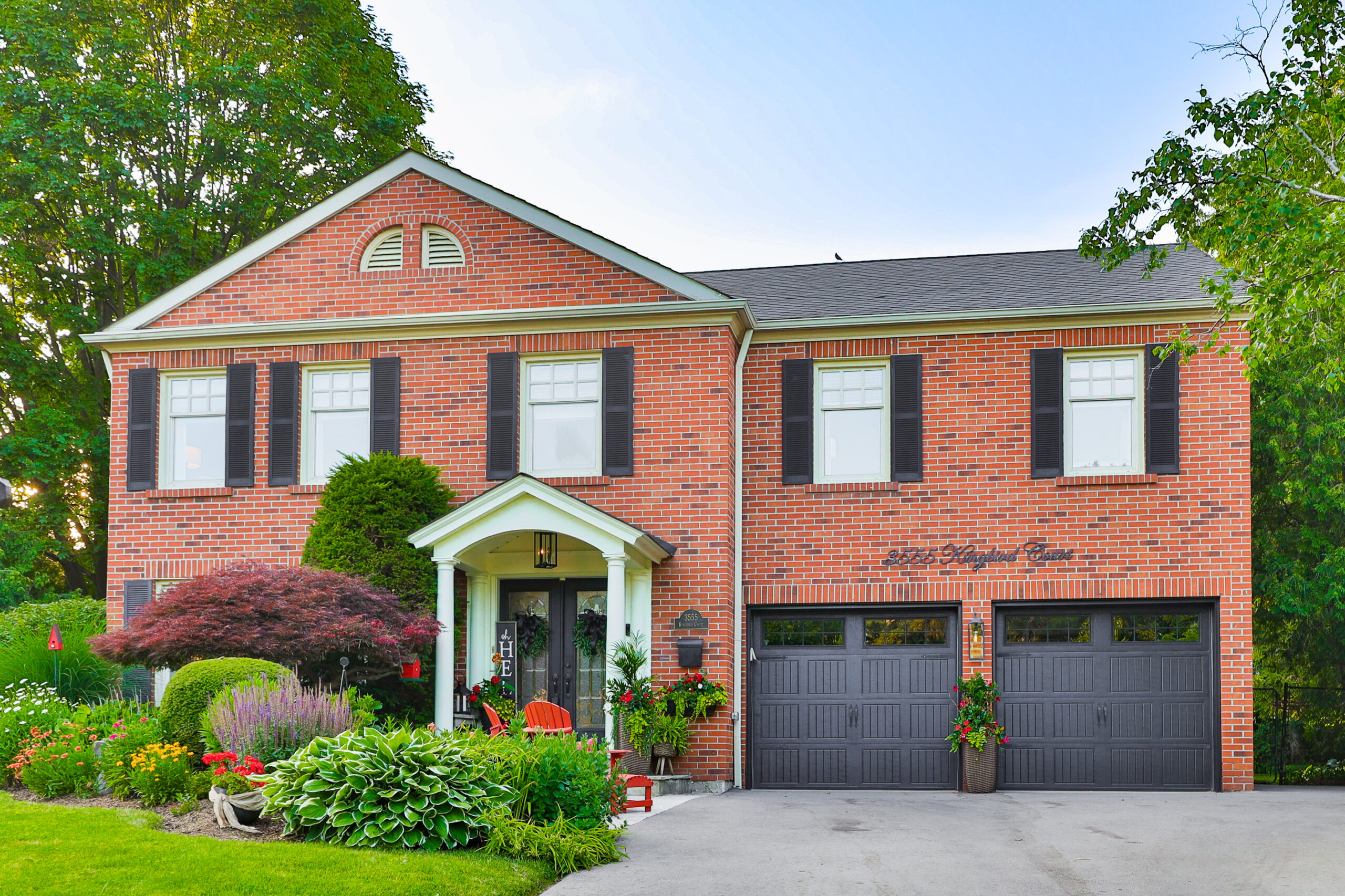 house photo with double garage and garden