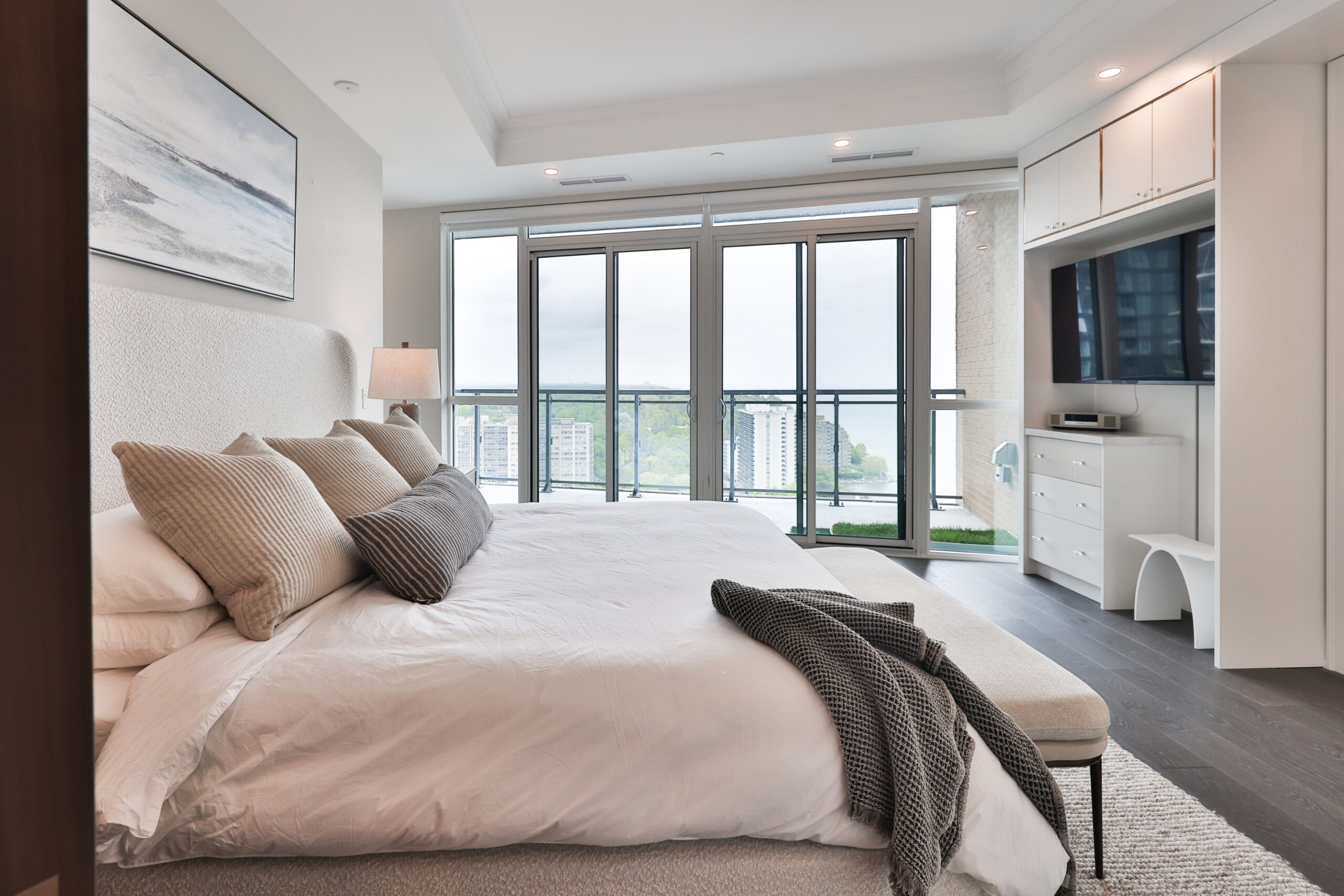 principal bedroom with built in cabinets and access to outdoor balcony