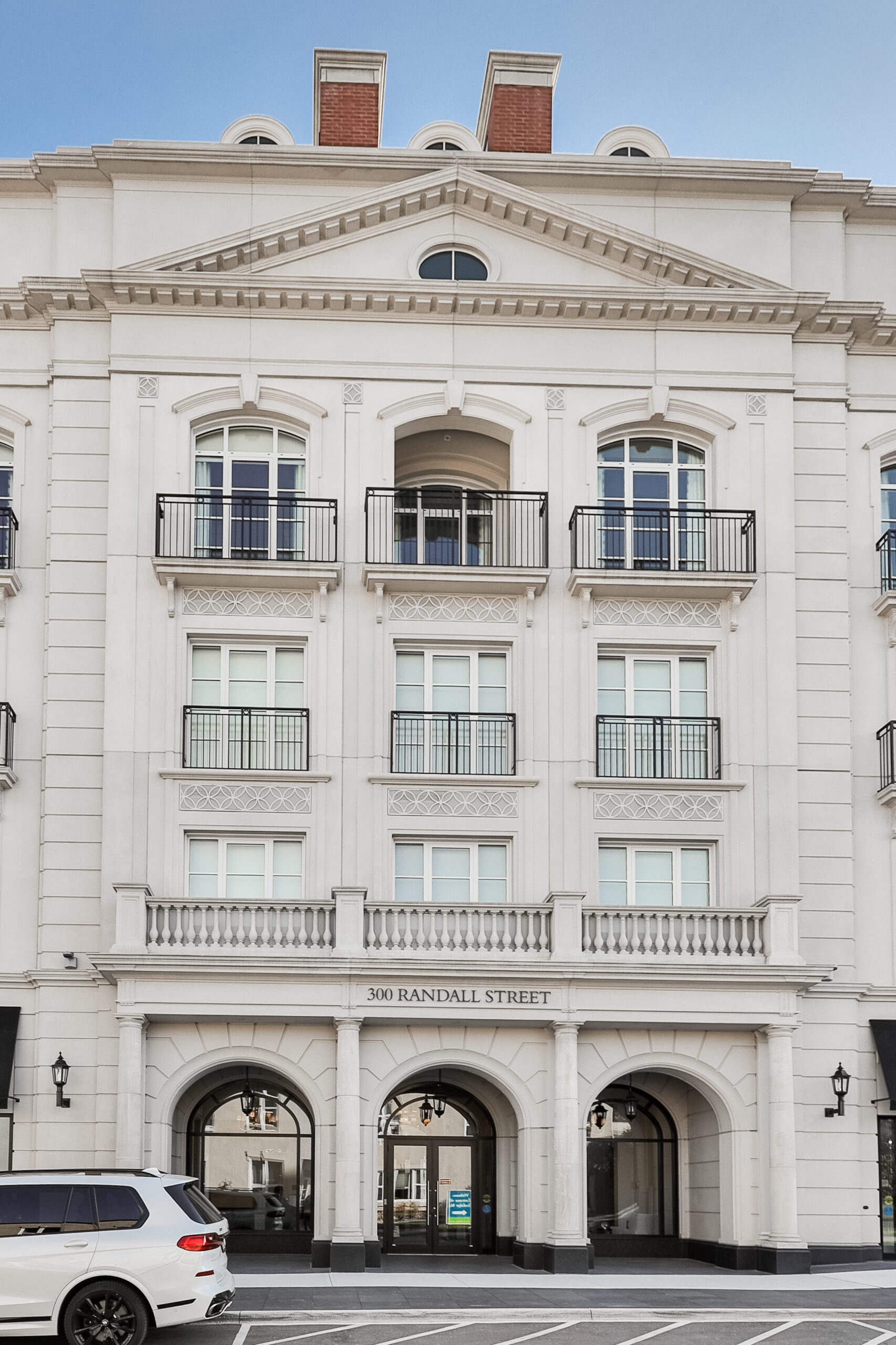 Elegant white building facade with balconies and arched entrances