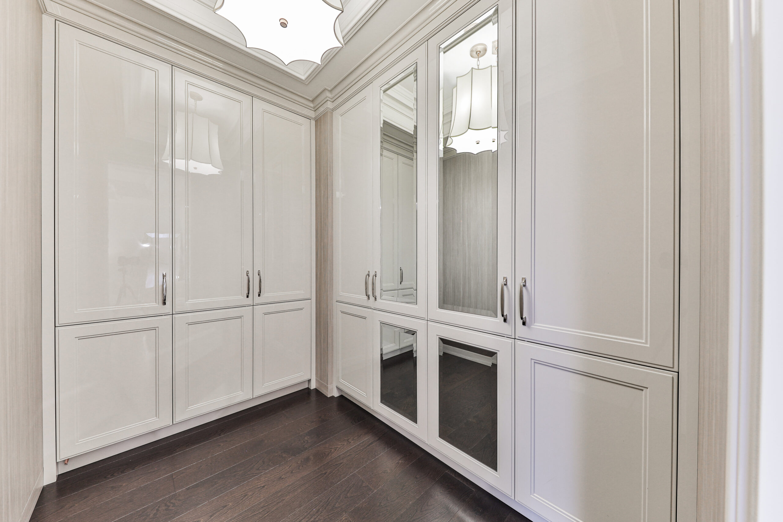 guest bedroom closet. high gloss white cabinetry with built in mirrors