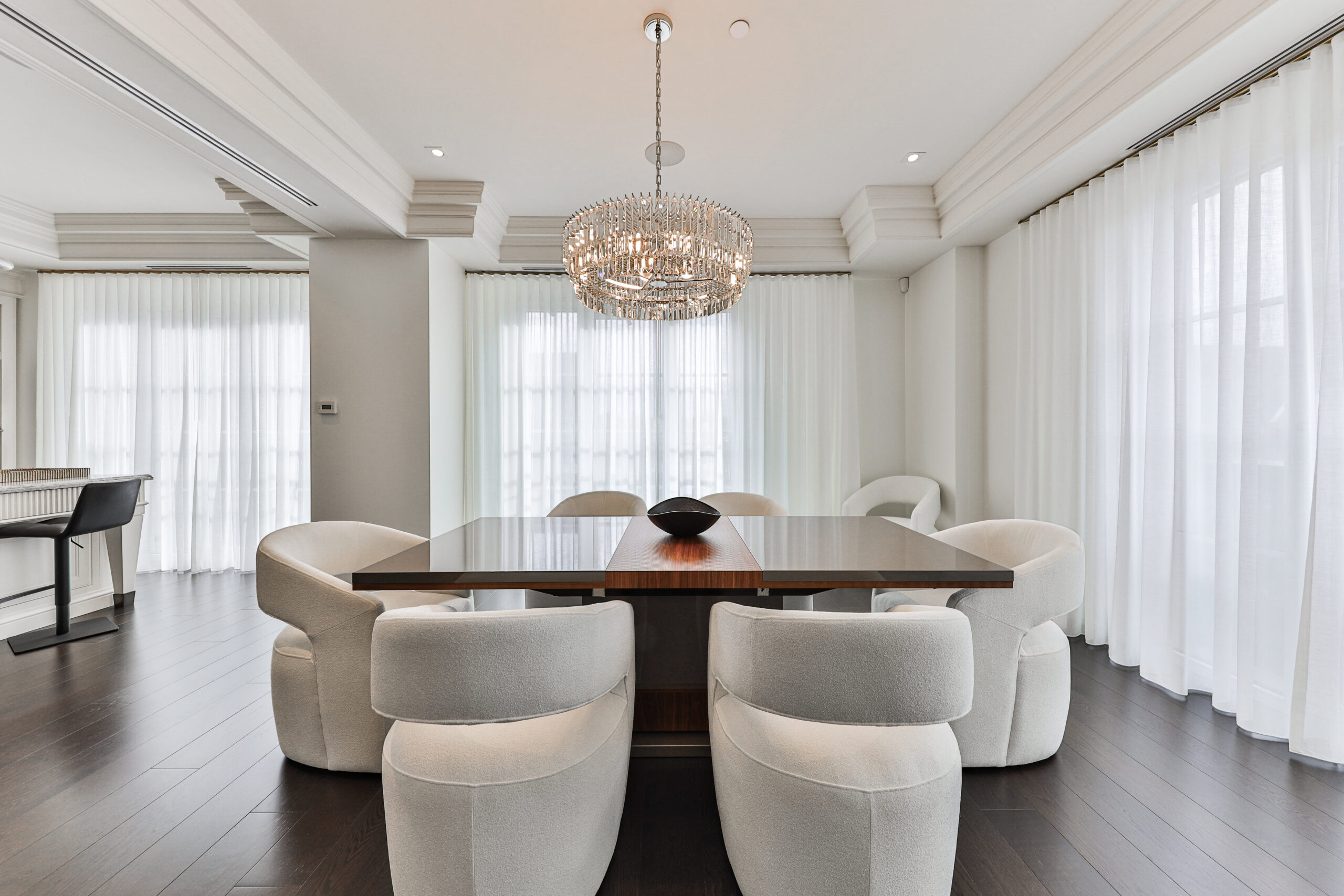 Modern dining room with a large table and plush white chairs