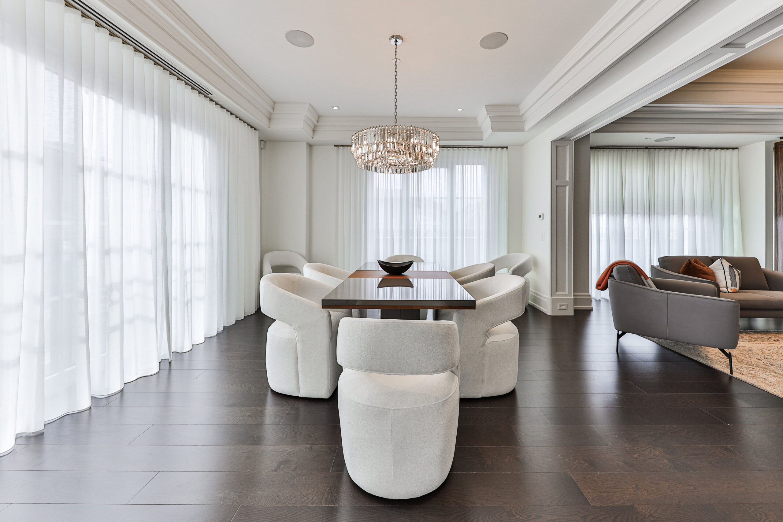 Modern dining area with a round table and plush white chairs