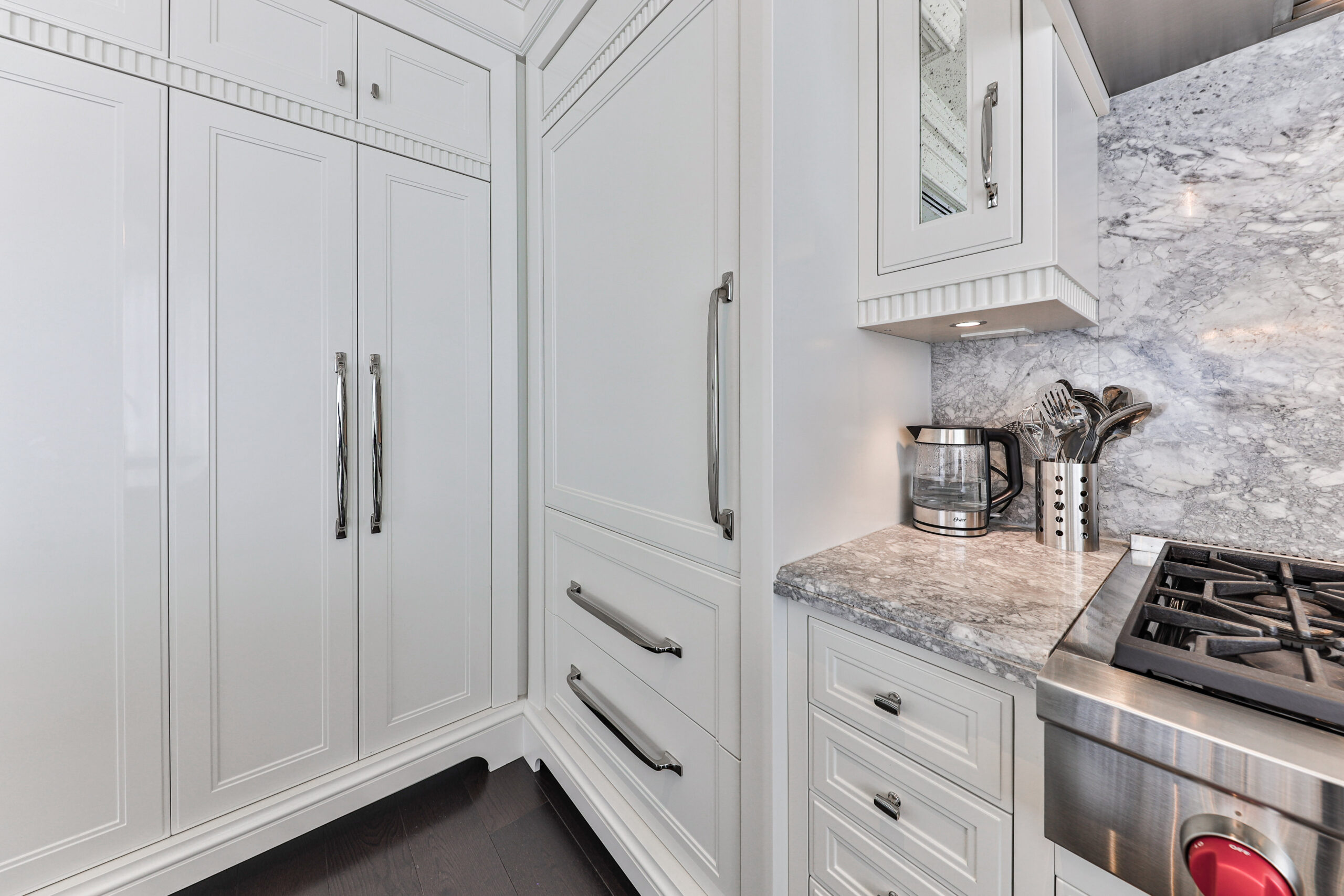 Modern kitchen with white cabinetry and marble backsplash