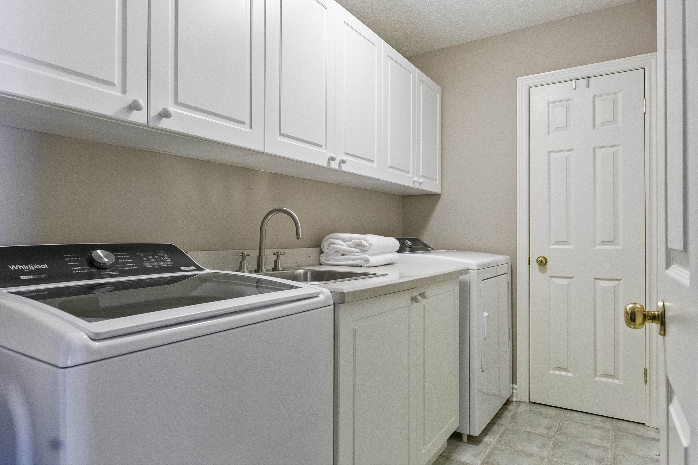 laundry room featuring sink and lots of cabinet space