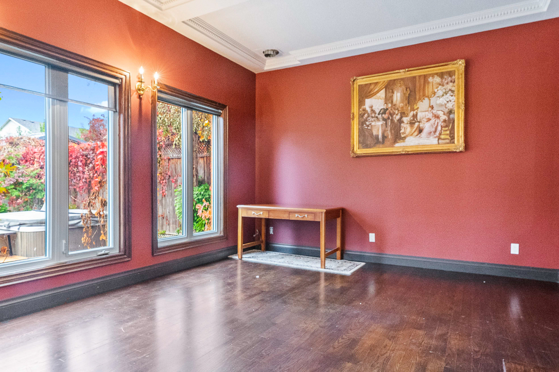 Empty room with red walls, large windows, and wooden table