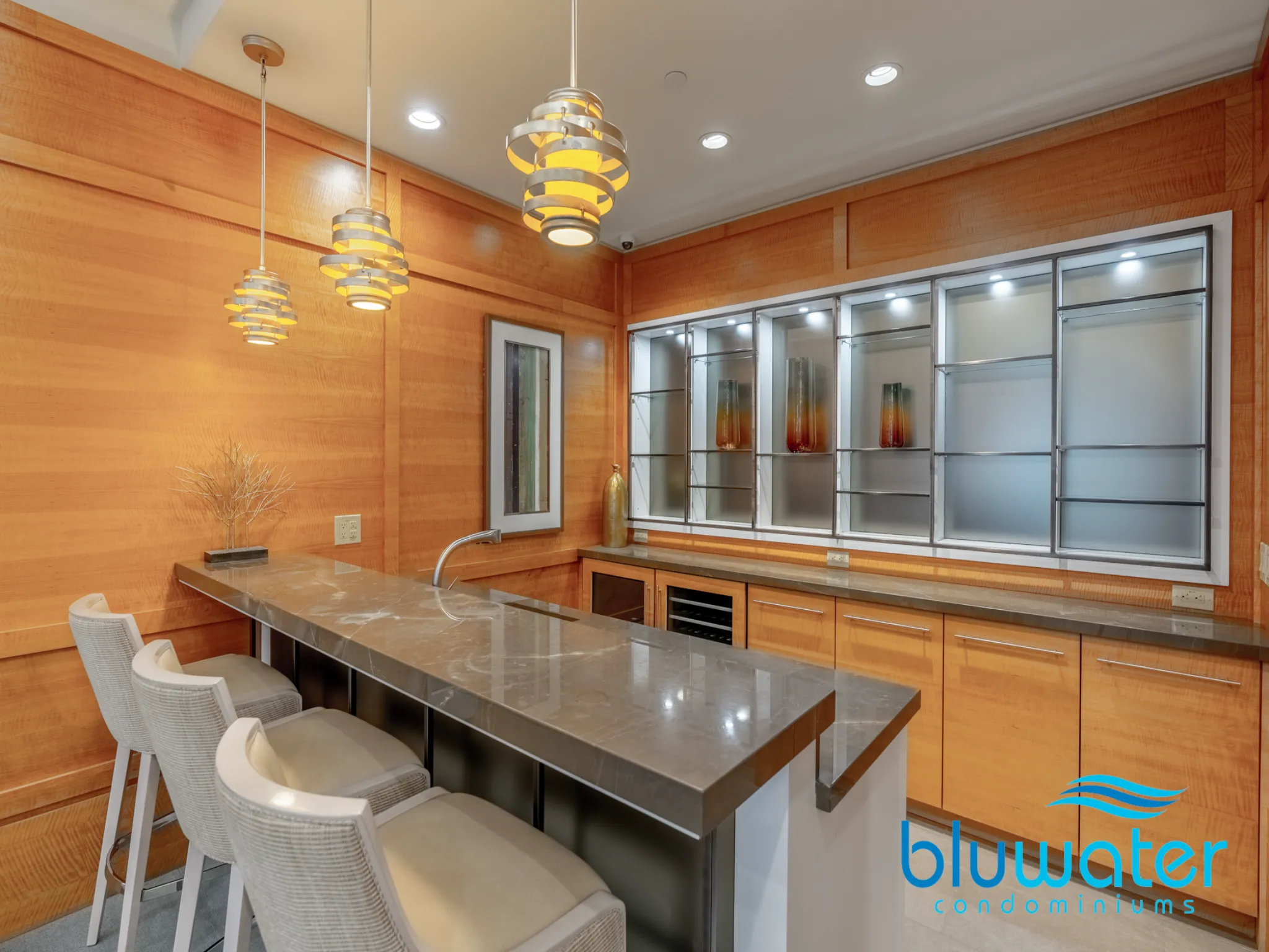 wood paneled walls with stylish pendant lights and a peninsula with seating for three