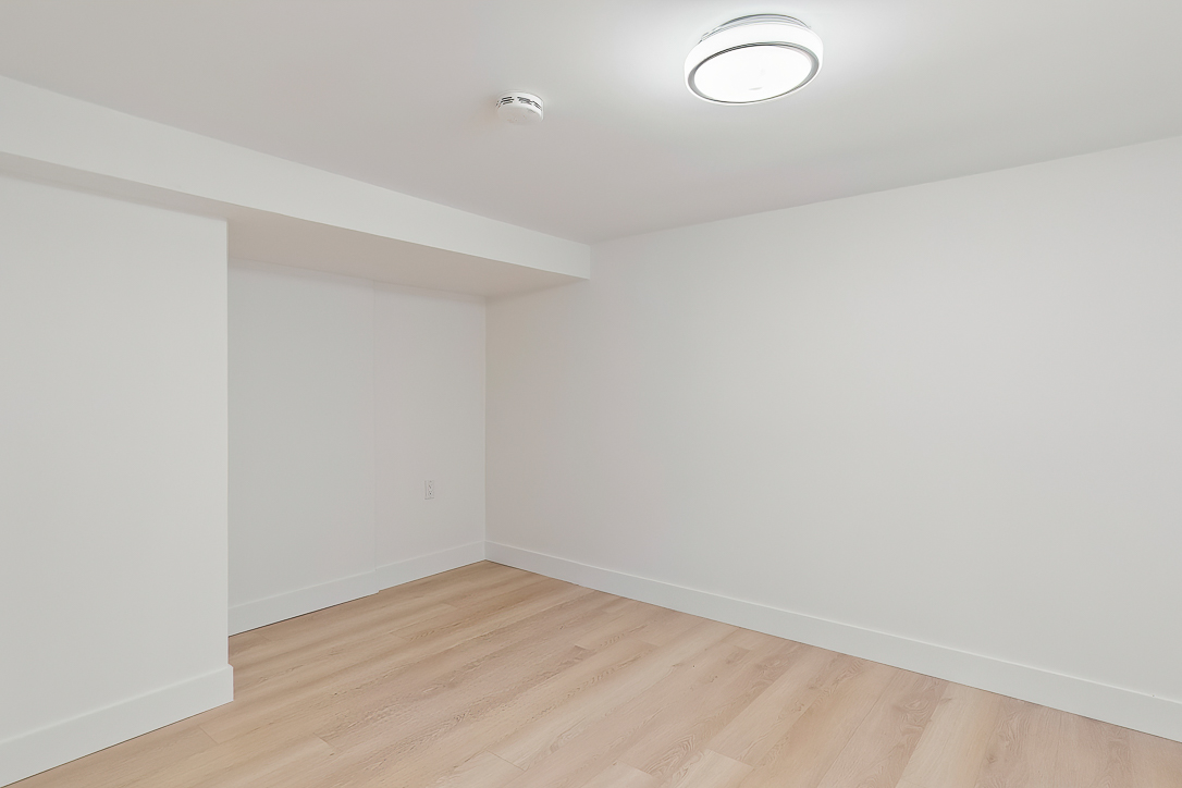 Empty room with light wood flooring and white walls