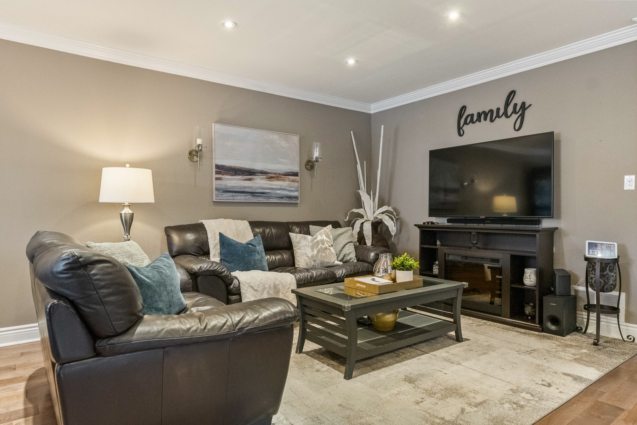 Cozy living room with leather sofas, a TV, and decorative accents