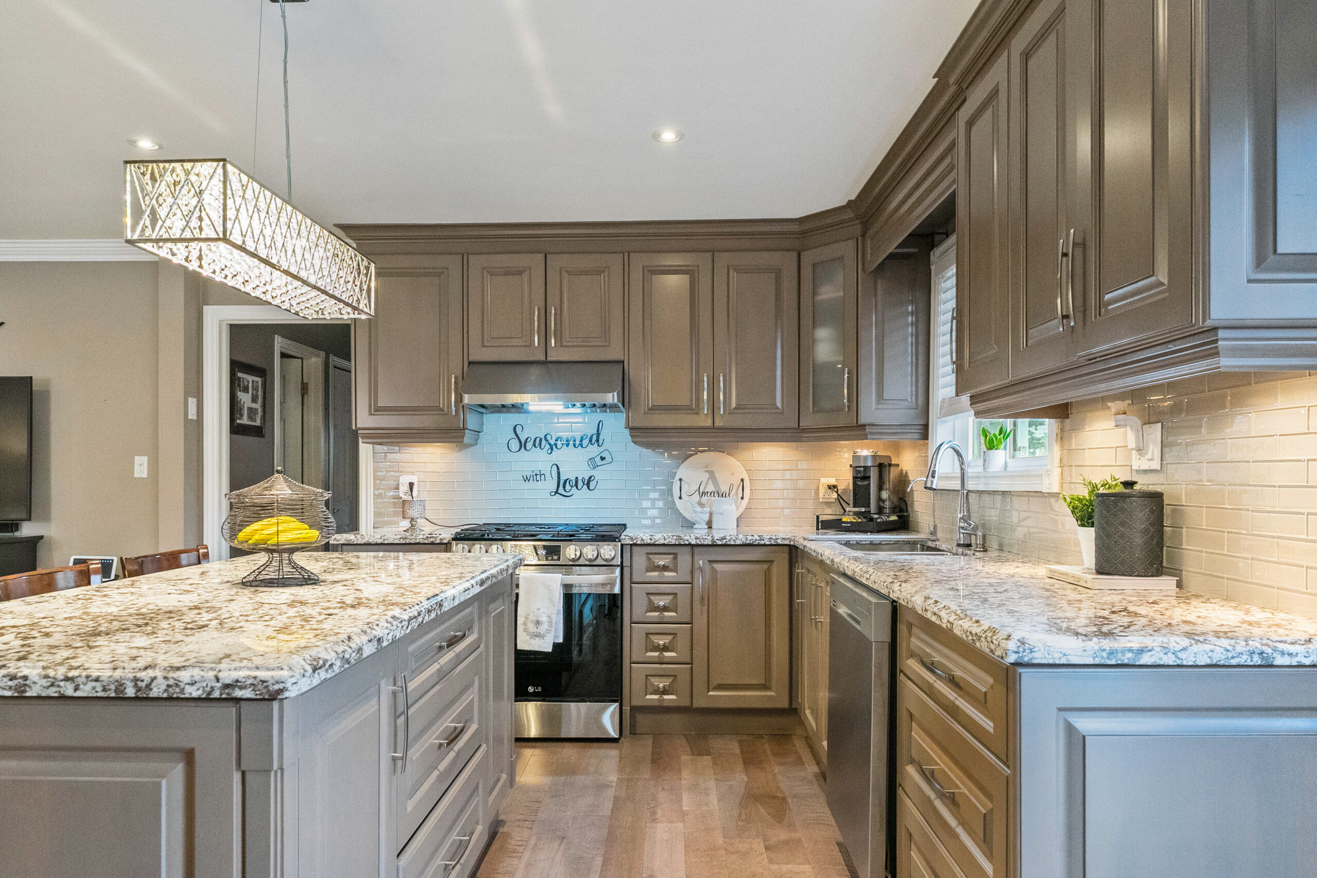 Modern kitchen with granite countertops, wooden cabinets, and stylish lighting.