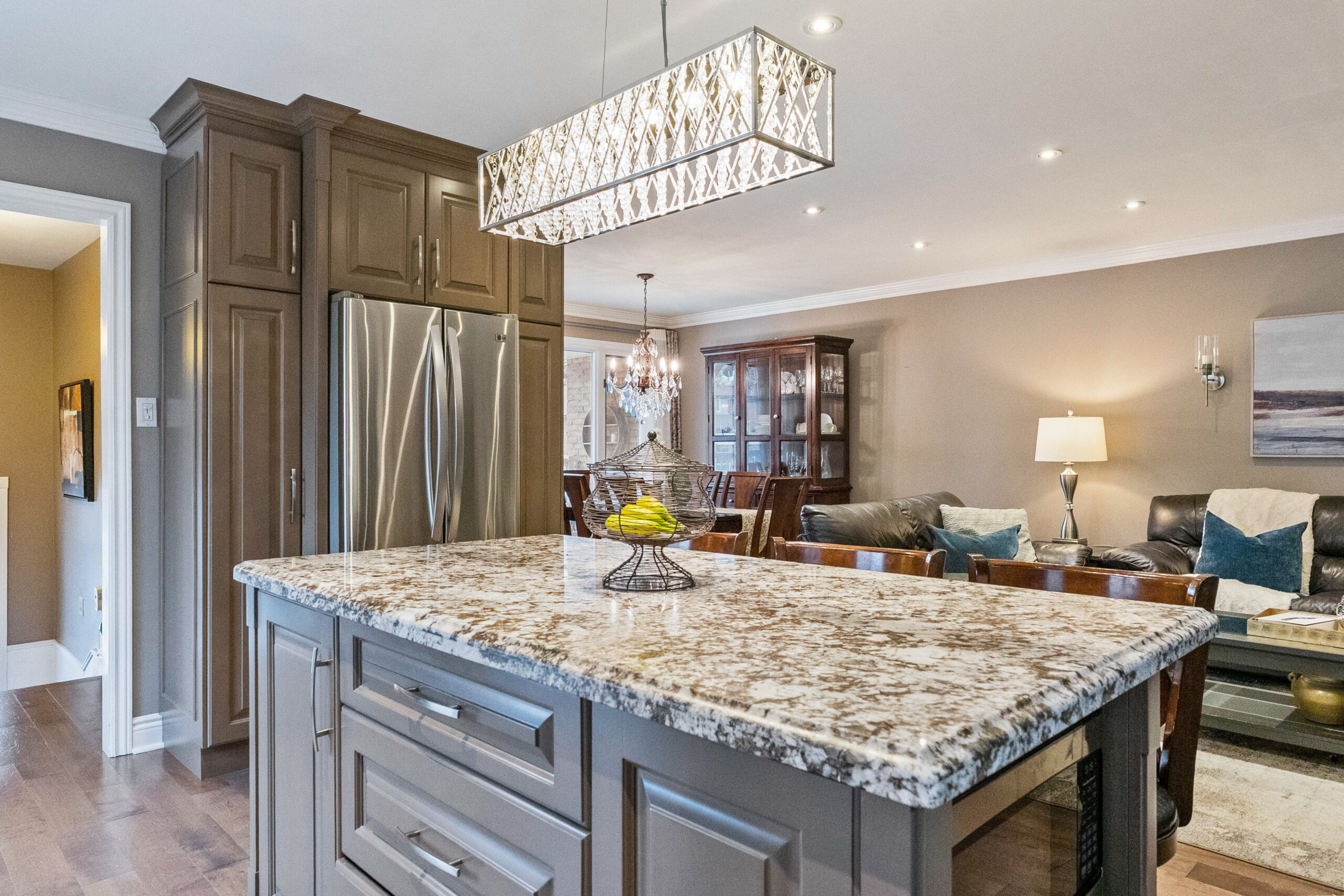 Modern kitchen with a large granite island and stylish chandelier