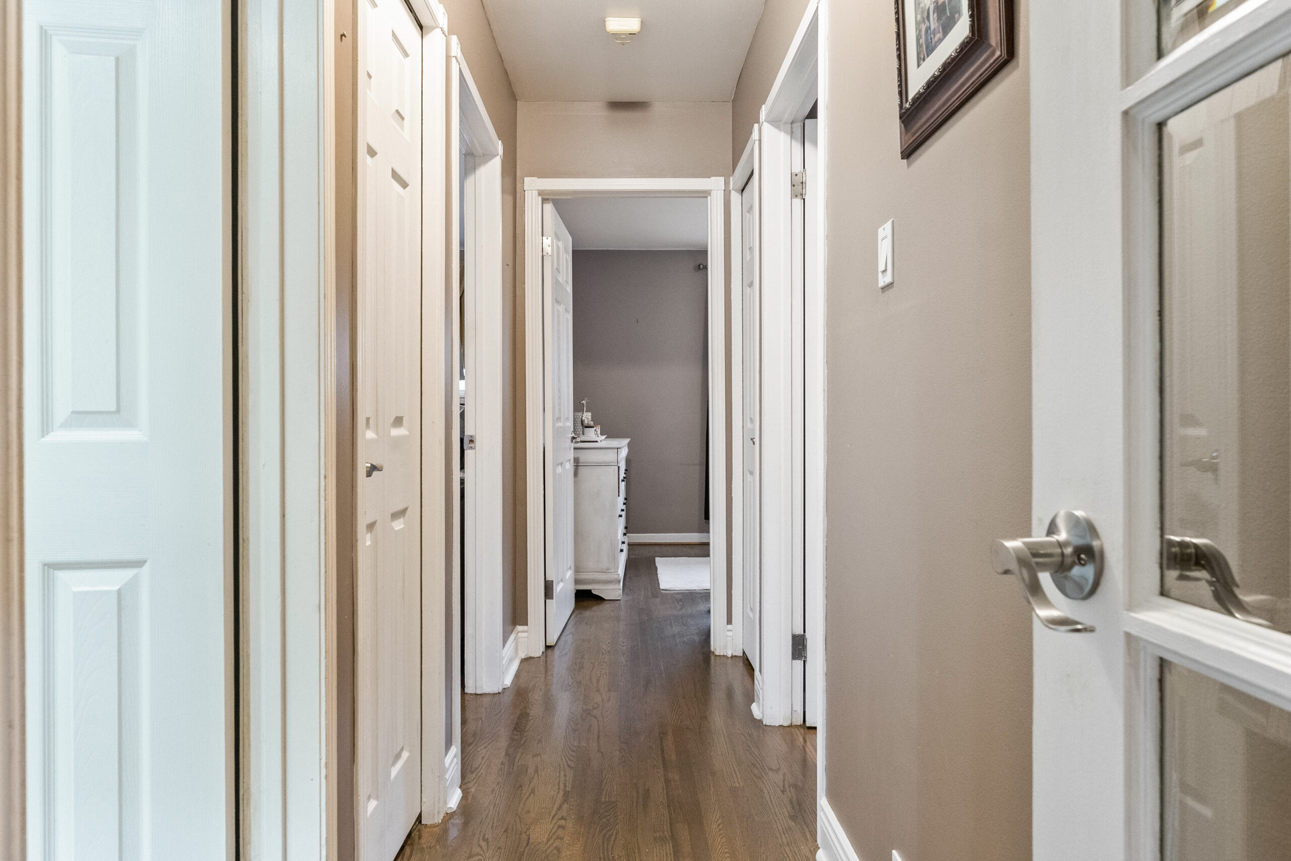 Long hallway with wooden floor and light-colored walls