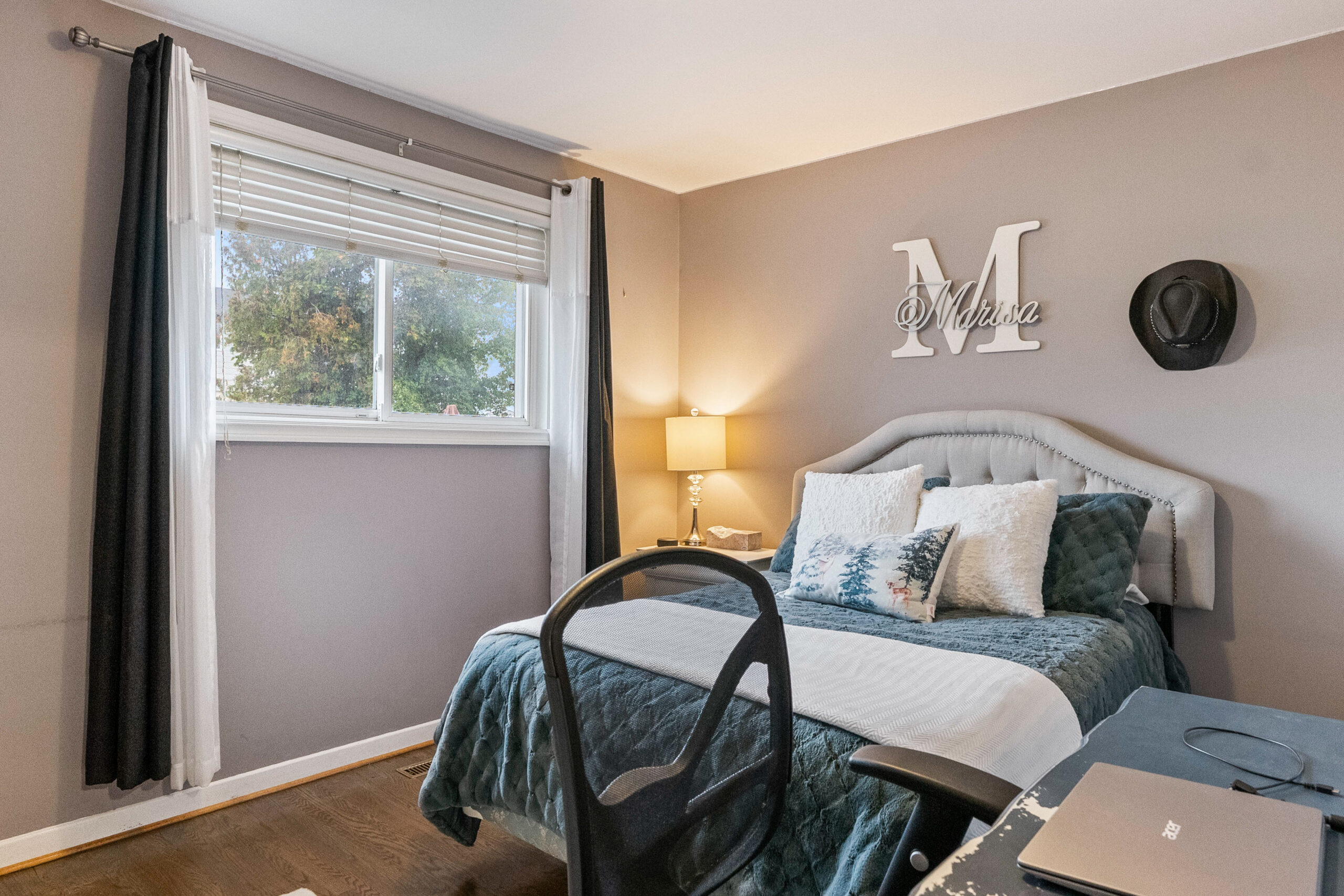 Cozy bedroom with a gray wall, bed, and window with curtains