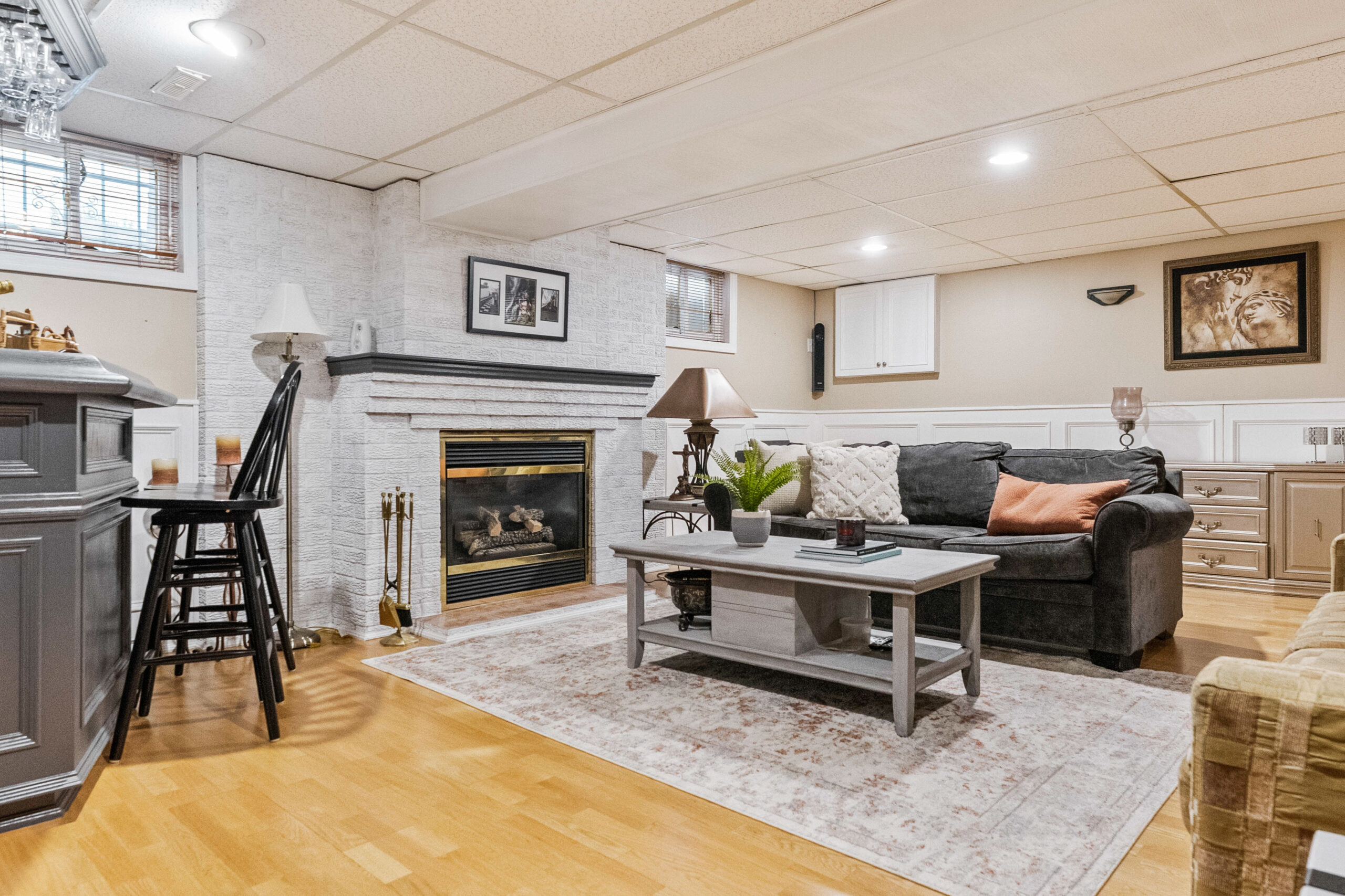 Cozy basement living area with a fireplace and comfortable seating