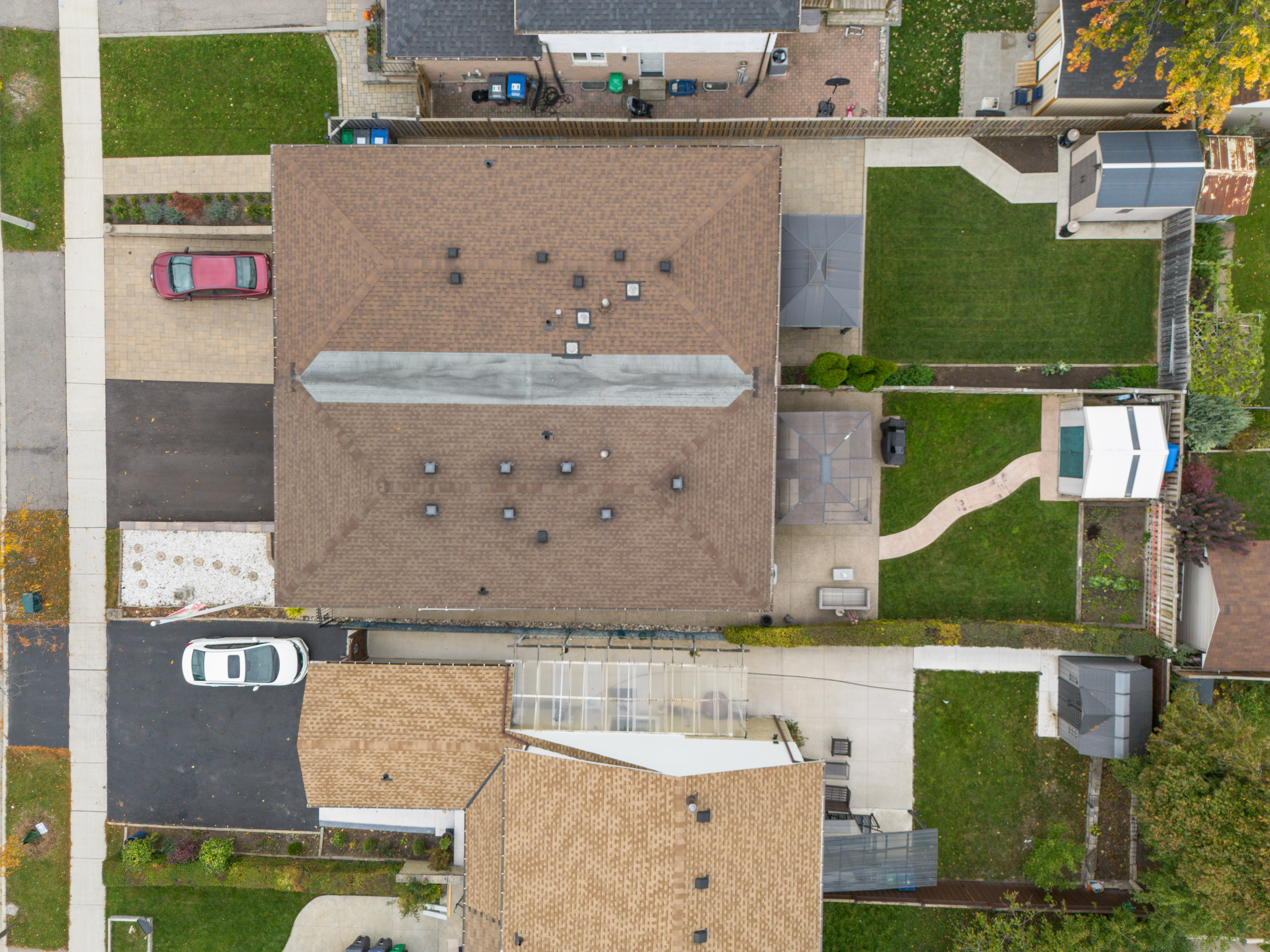 Aerial view of residential homes with brown roofs and green lawns