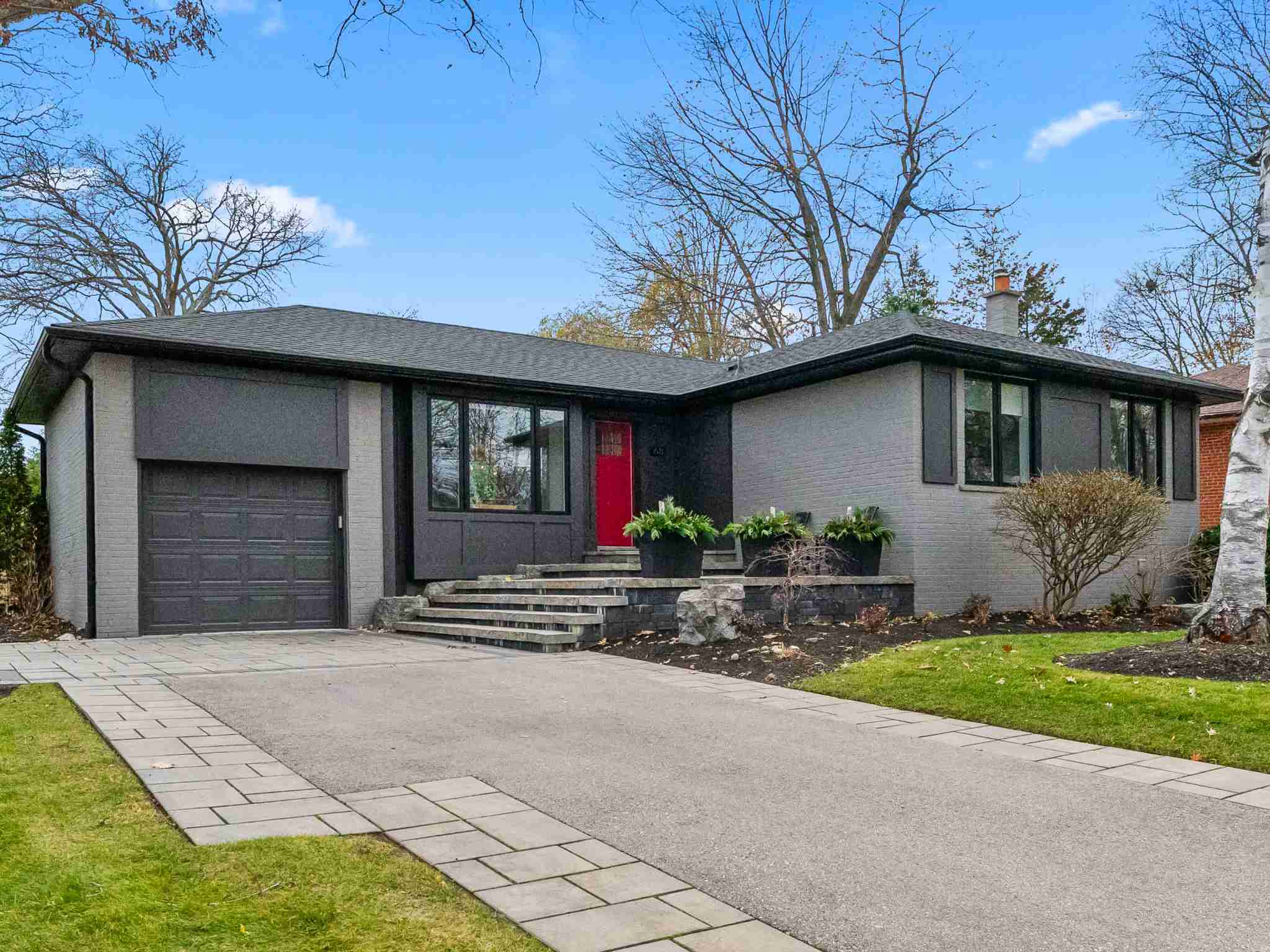 large wide drive way leading up to the red door