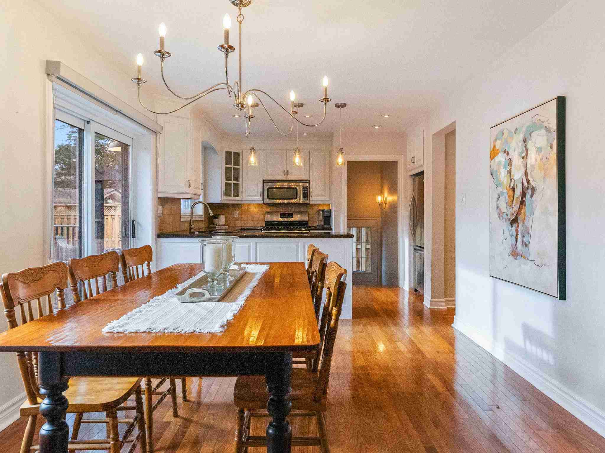 large dining room with chandelier leading into the kitchen