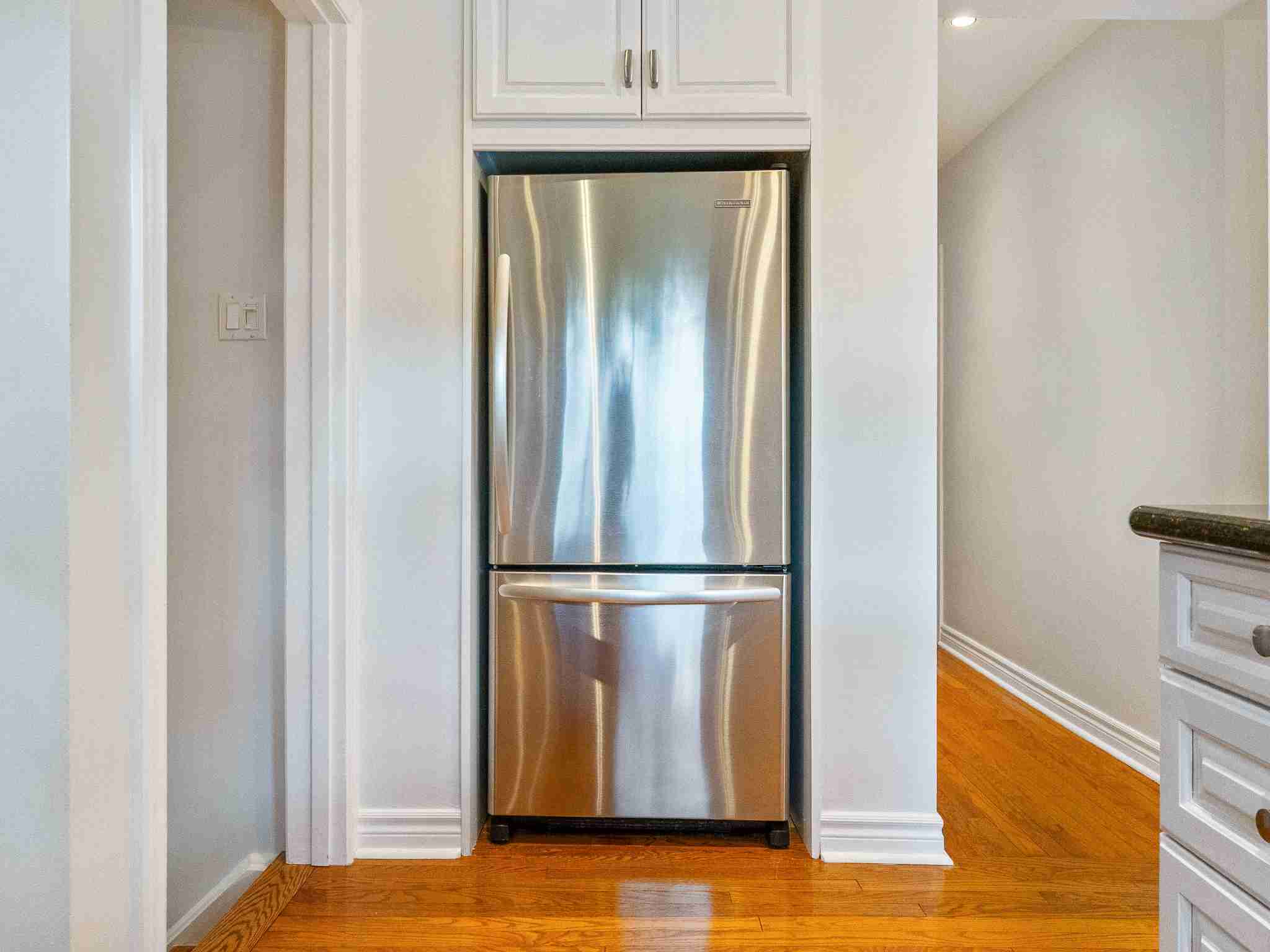 large stainless steel fridge with storage above