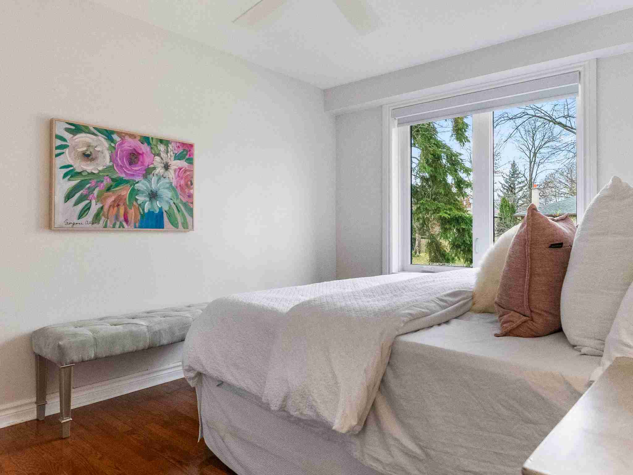 large principal bedroom with high ceilings and hardwood floor