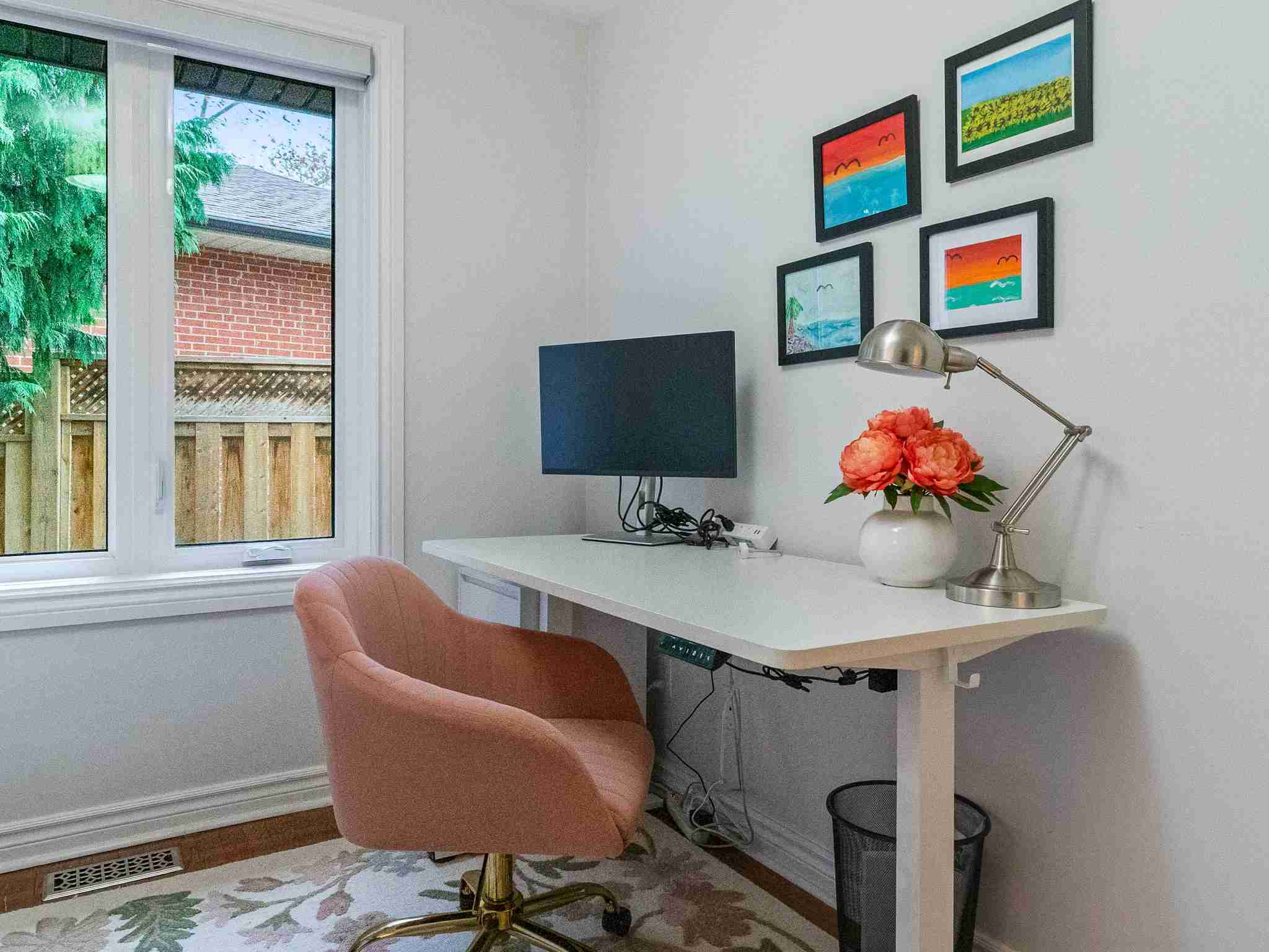 bedroom 2 with large window. currently being used as an office workspace