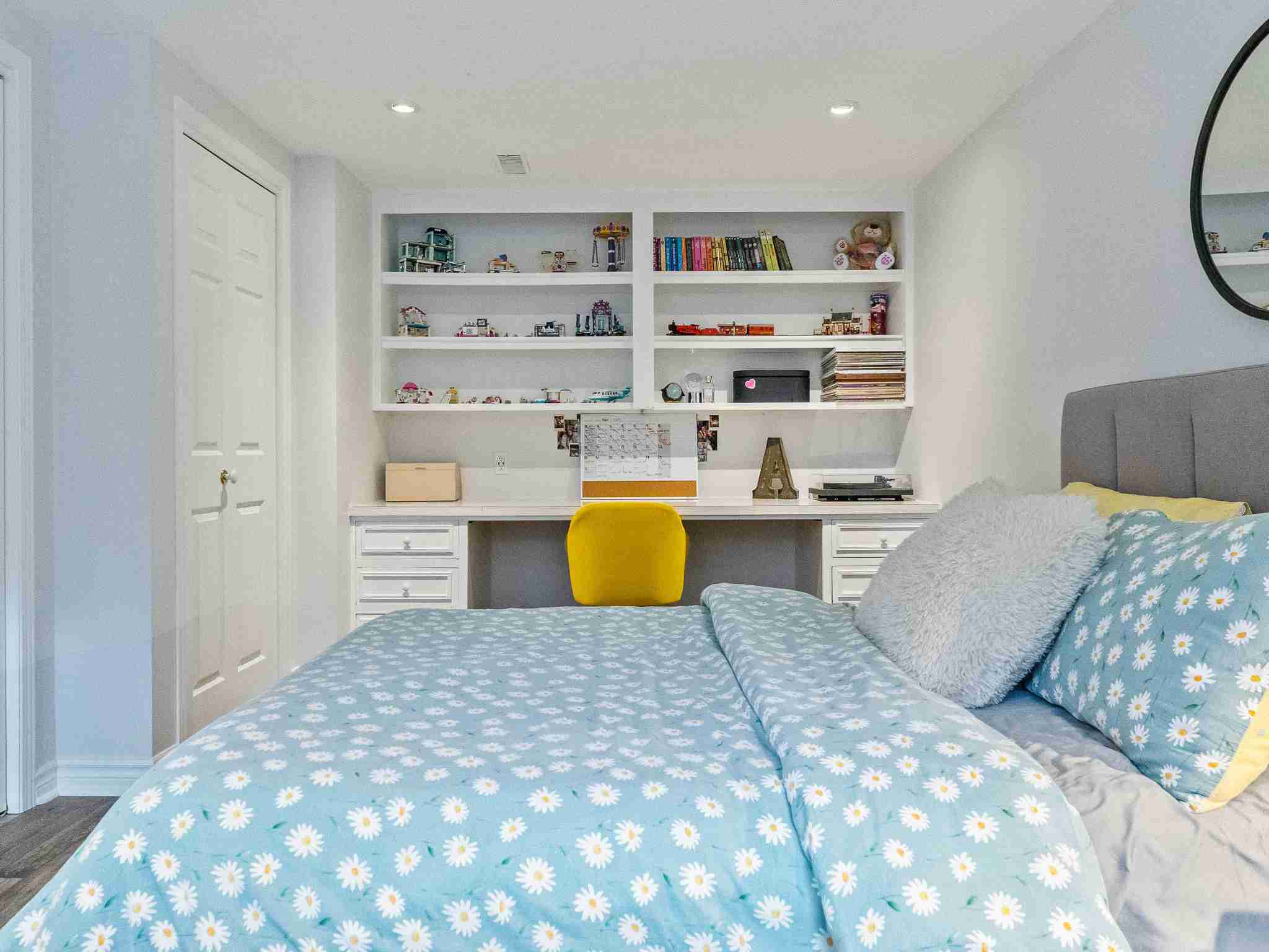 lower level bedroom with desk and custom built shelfs for storage