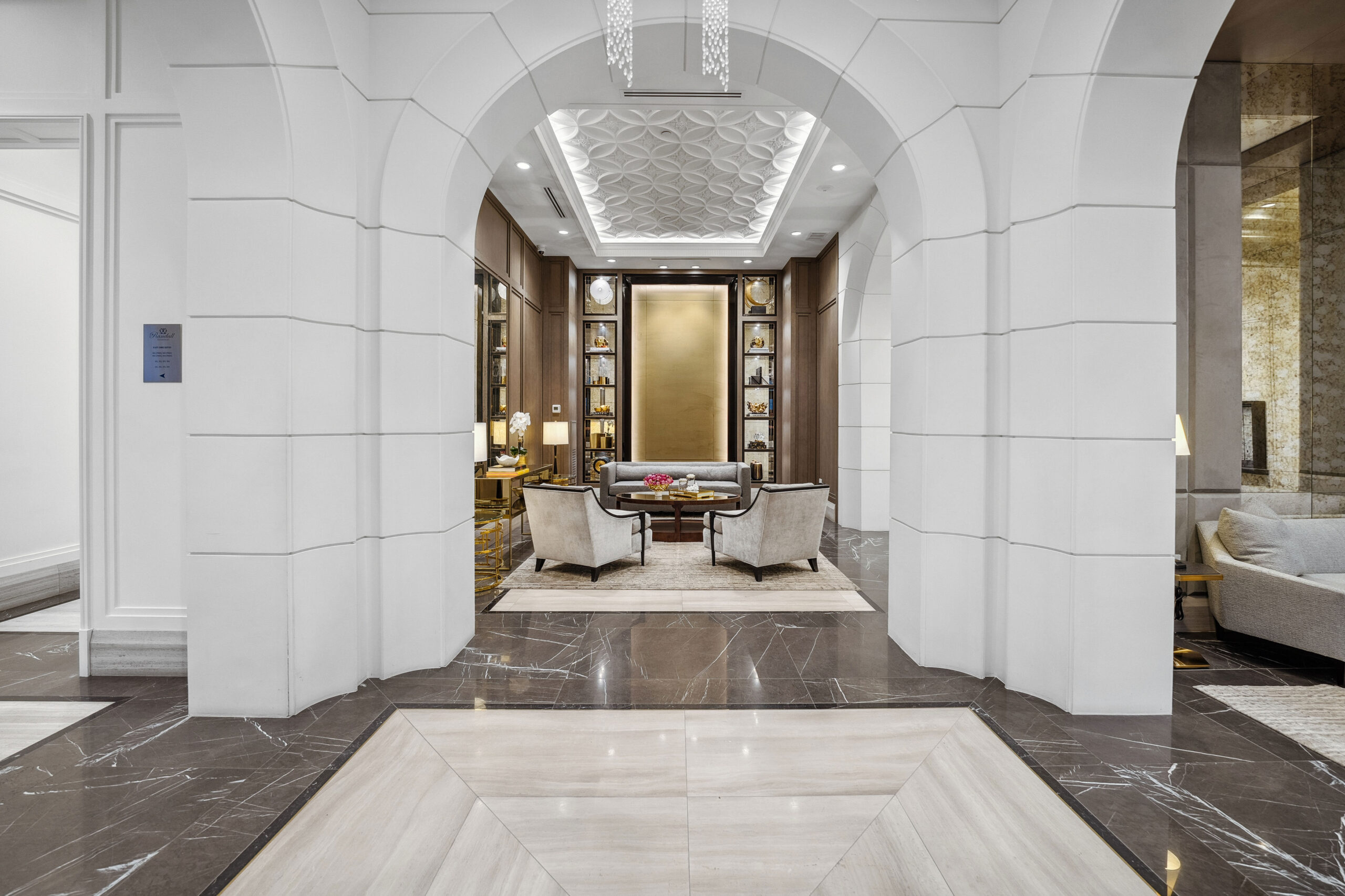 Elegant lobby with arched entrance, marble floors, and stylish seating area