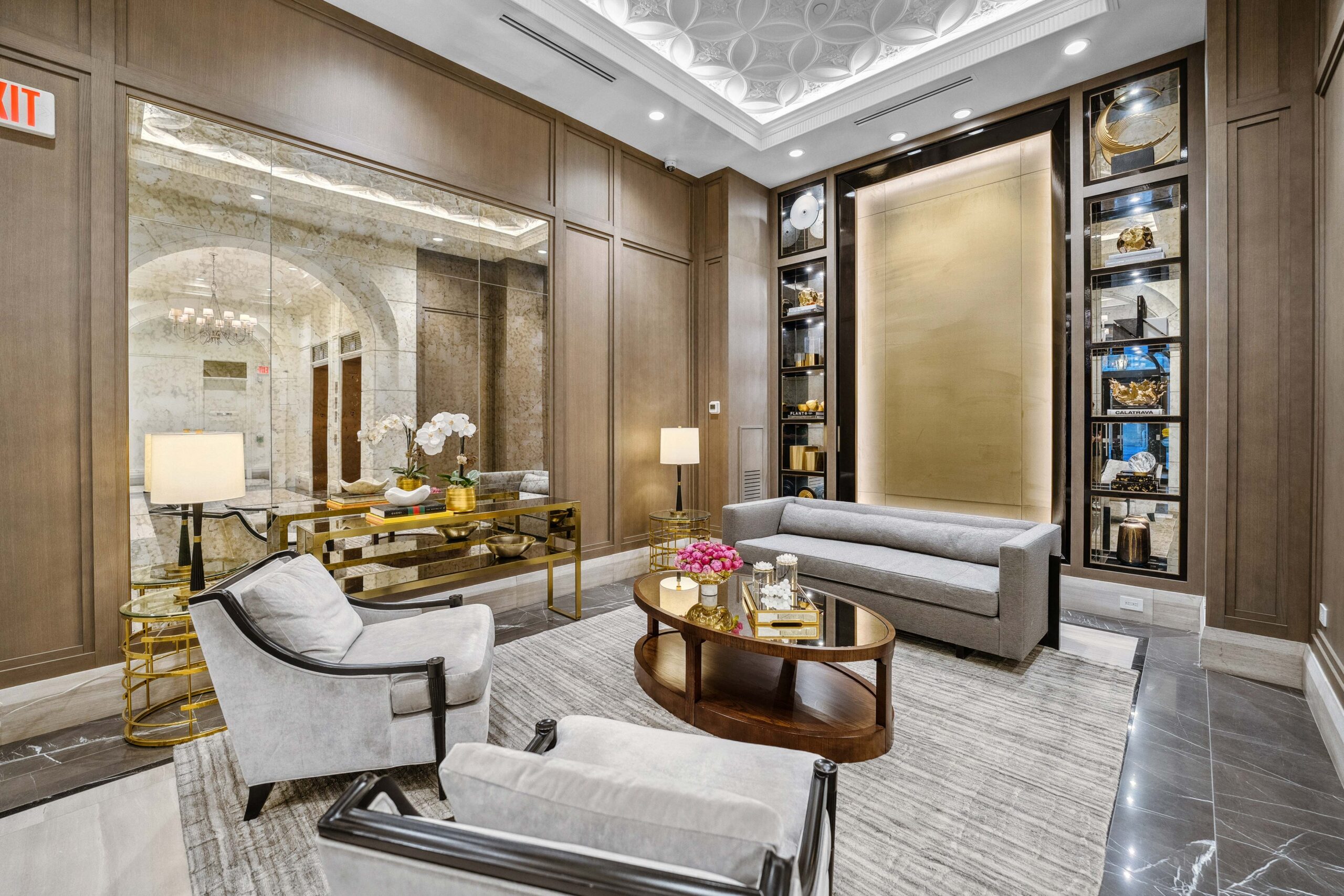 Modern lounge with gray sofas, glass coffee table, and decorative shelves