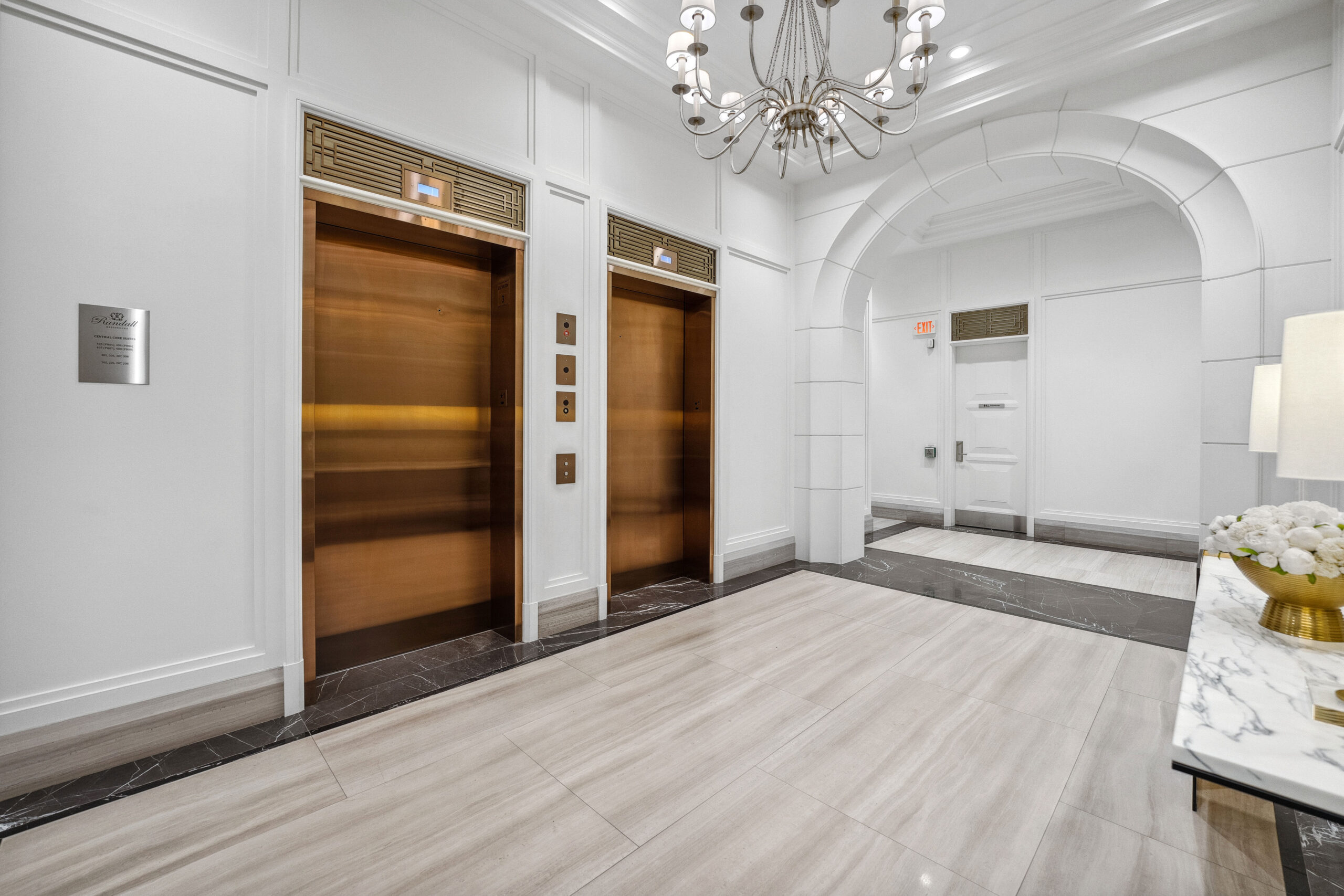 Elegant hotel lobby with two elevators and a chandelier