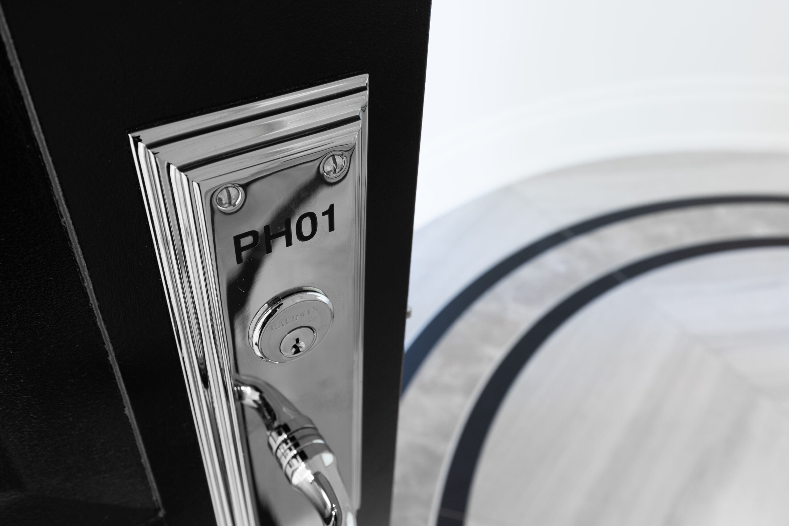 Close-up of a door lock with the number "PH01" and a circular floor design