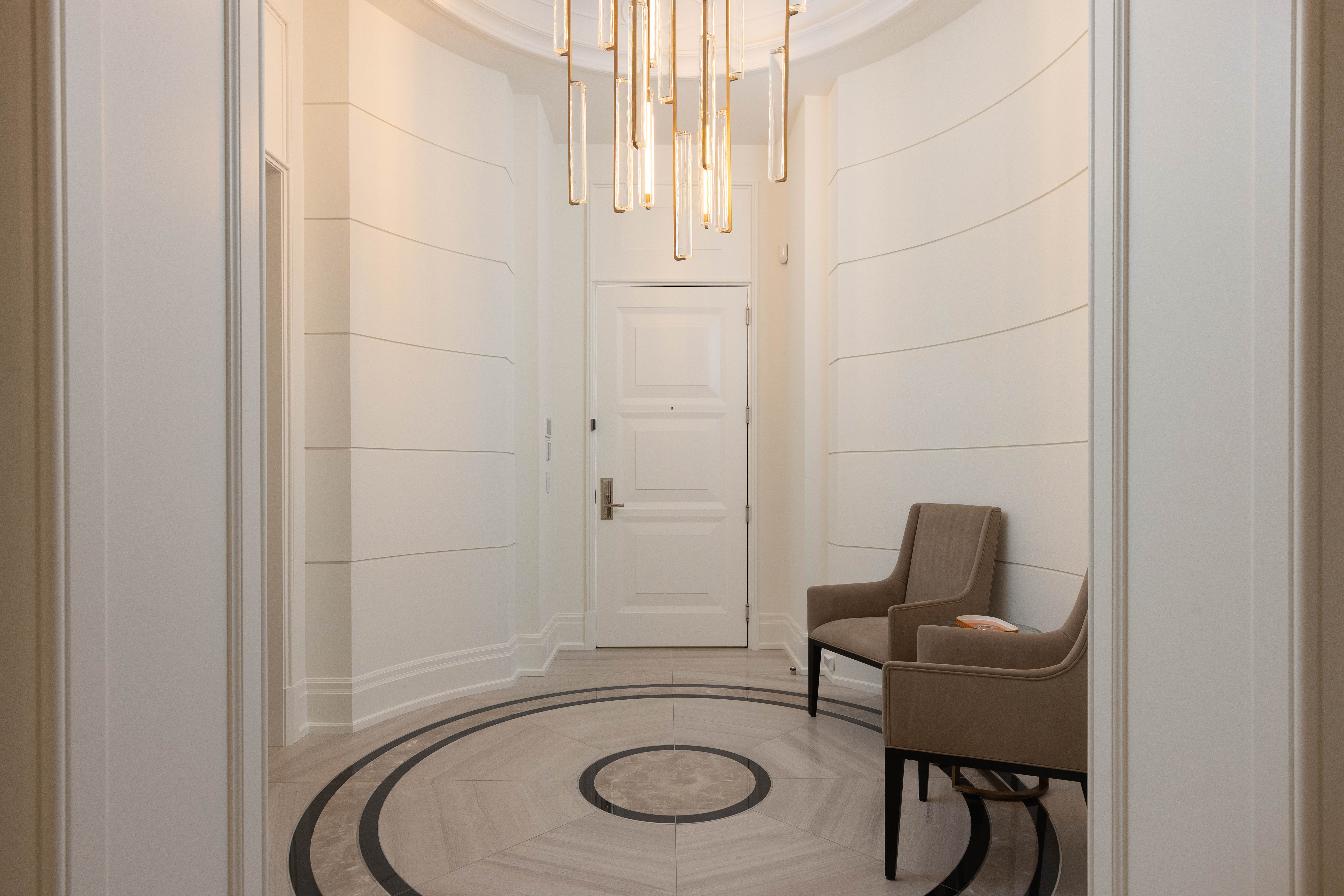 Elegant hallway with a circular patterned floor and modern lighting fixtures