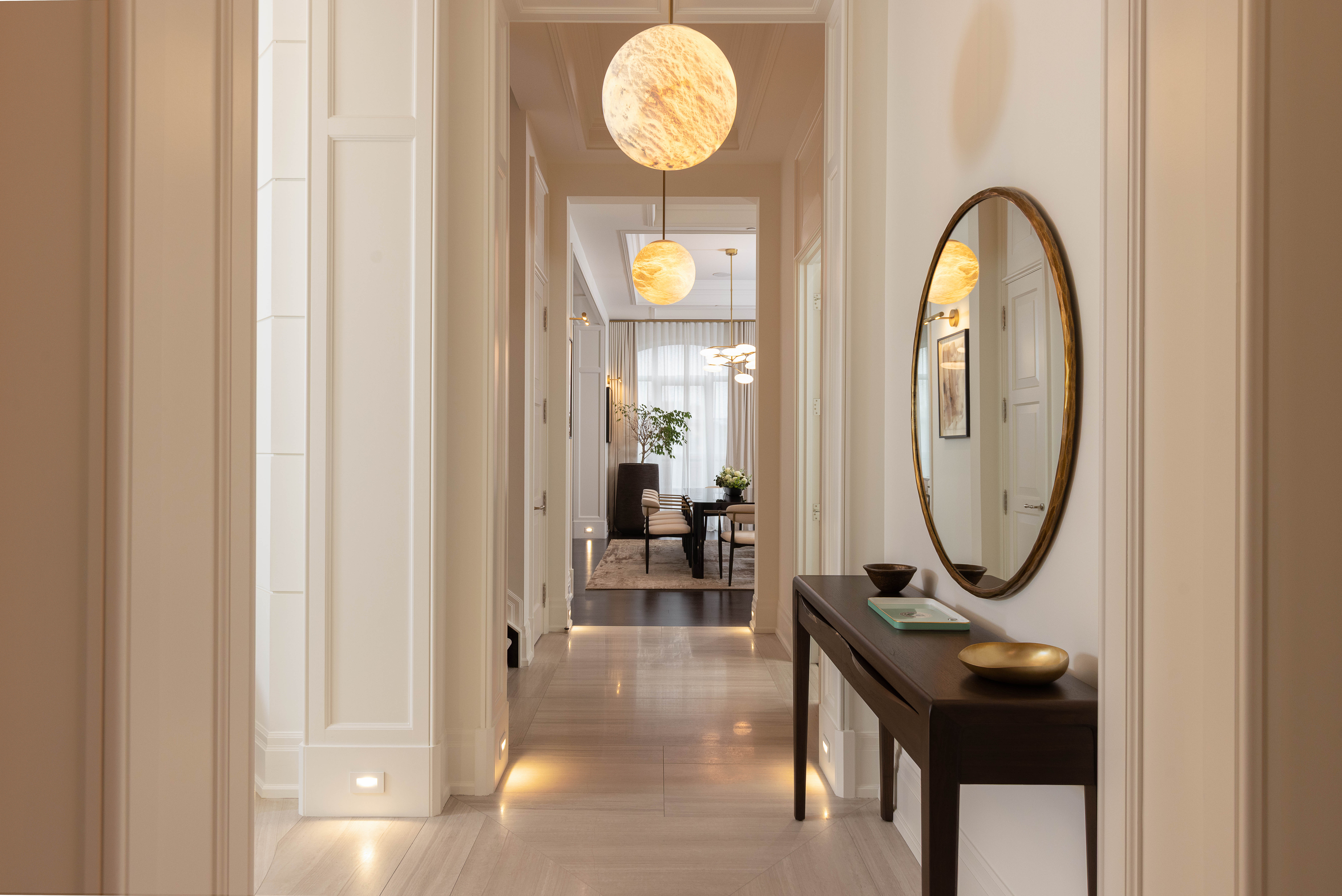 Elegant hallway with round mirror and decorative lighting fixtures