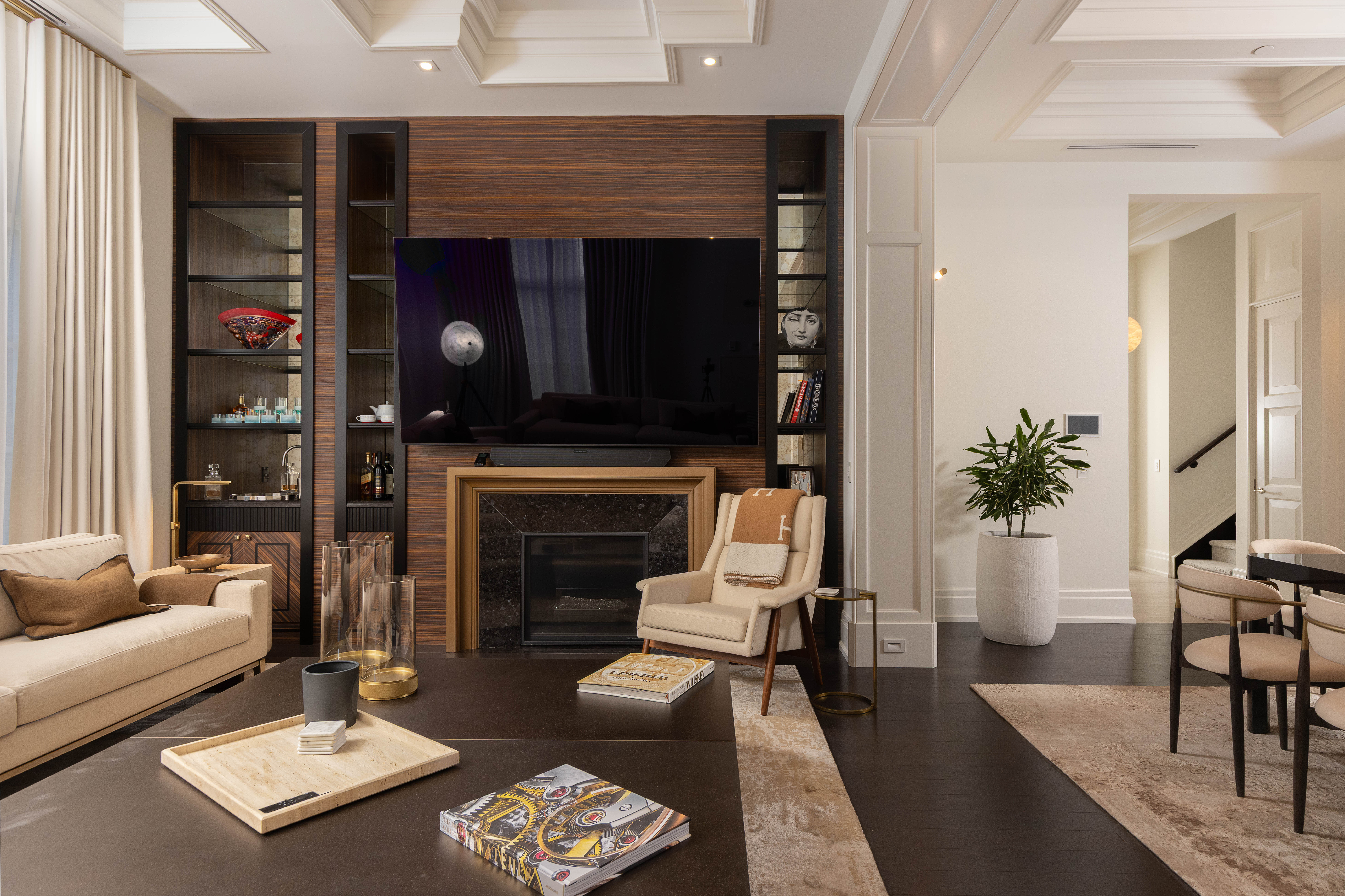 Modern living room with a large TV, cozy seating, and decorative shelves