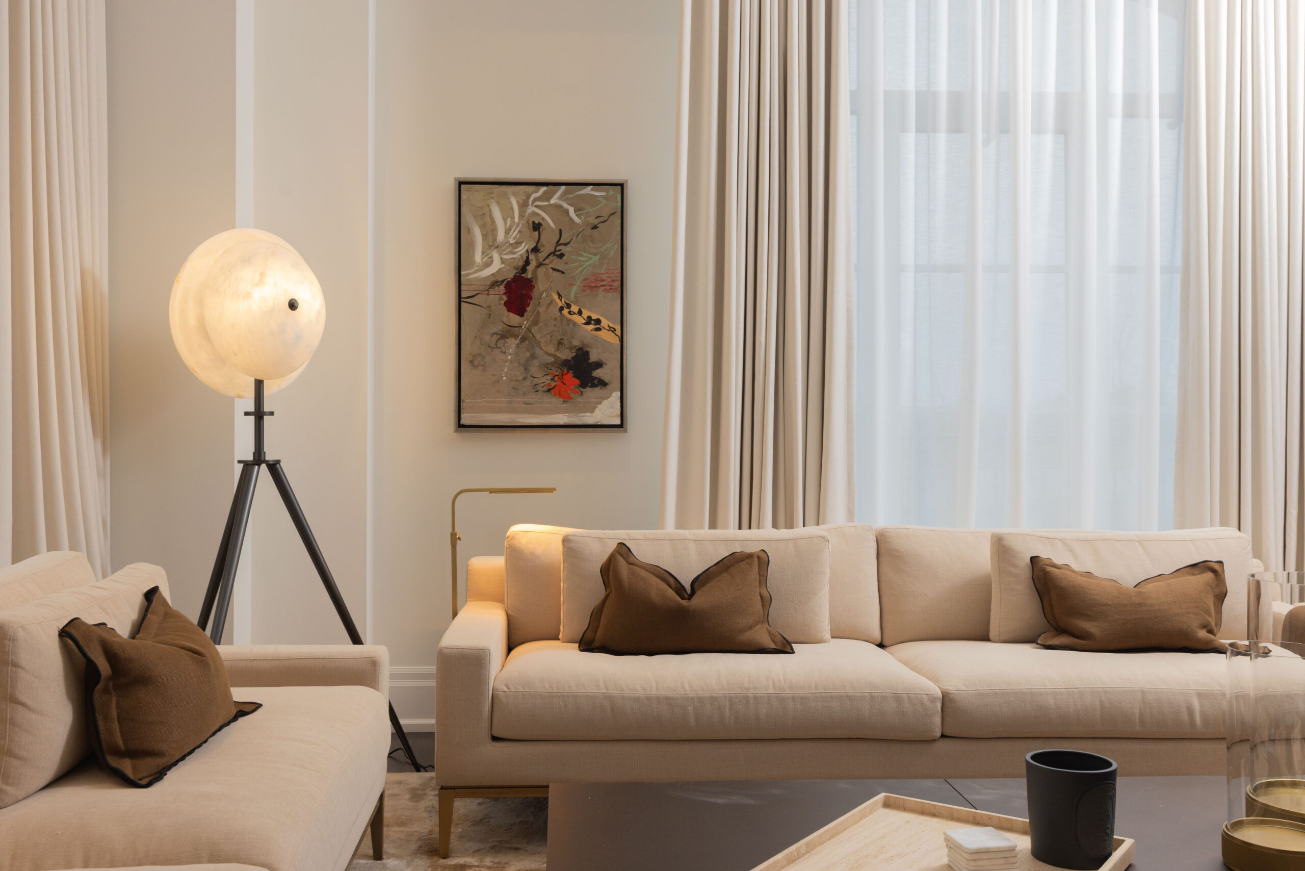 Modern living room with beige sofa, decorative pillows, and stylish lamp