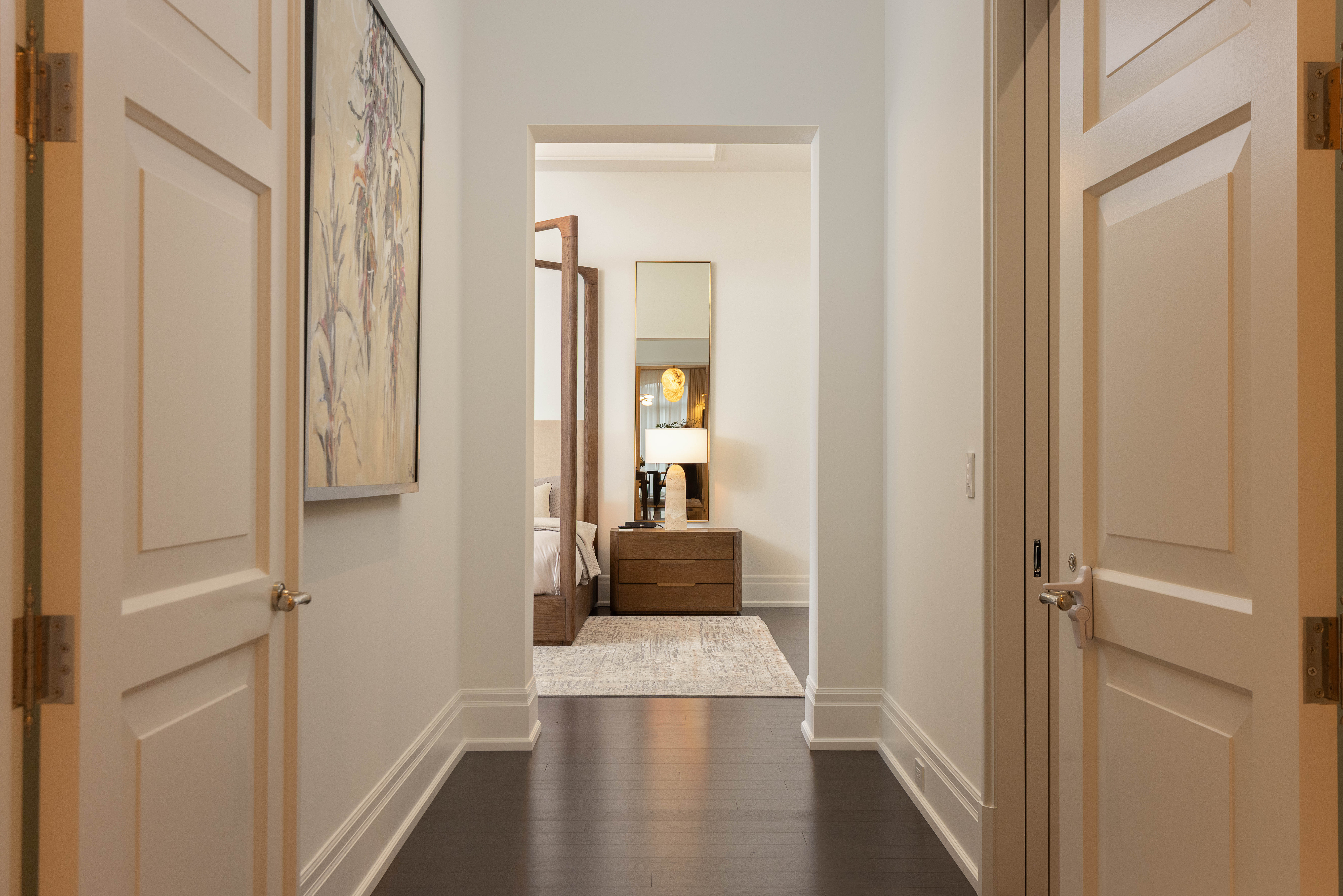 Bright hallway with open doors leading to a stylish room at the end