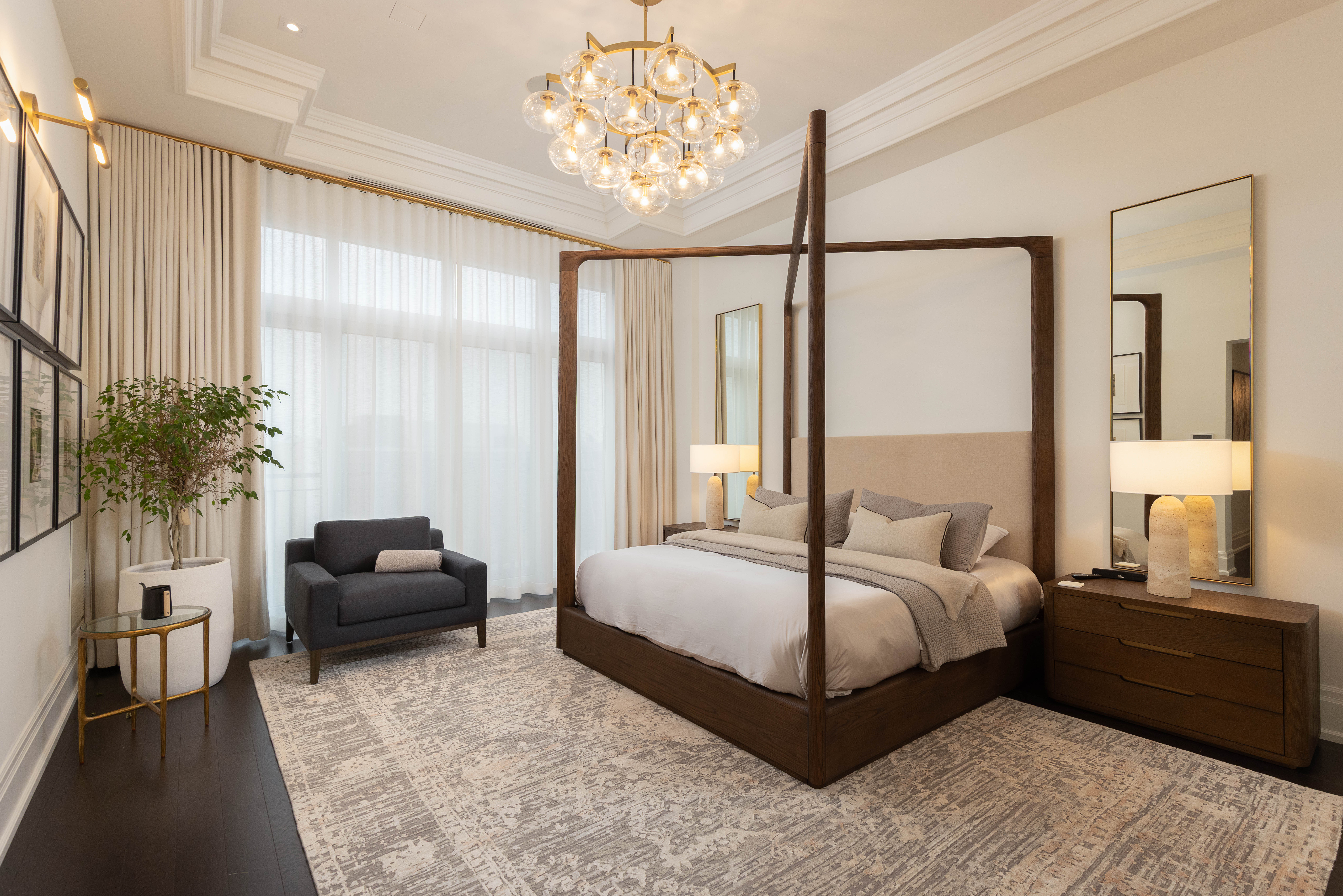 Elegant bedroom featuring a four-poster bed, armchair, and chandelier