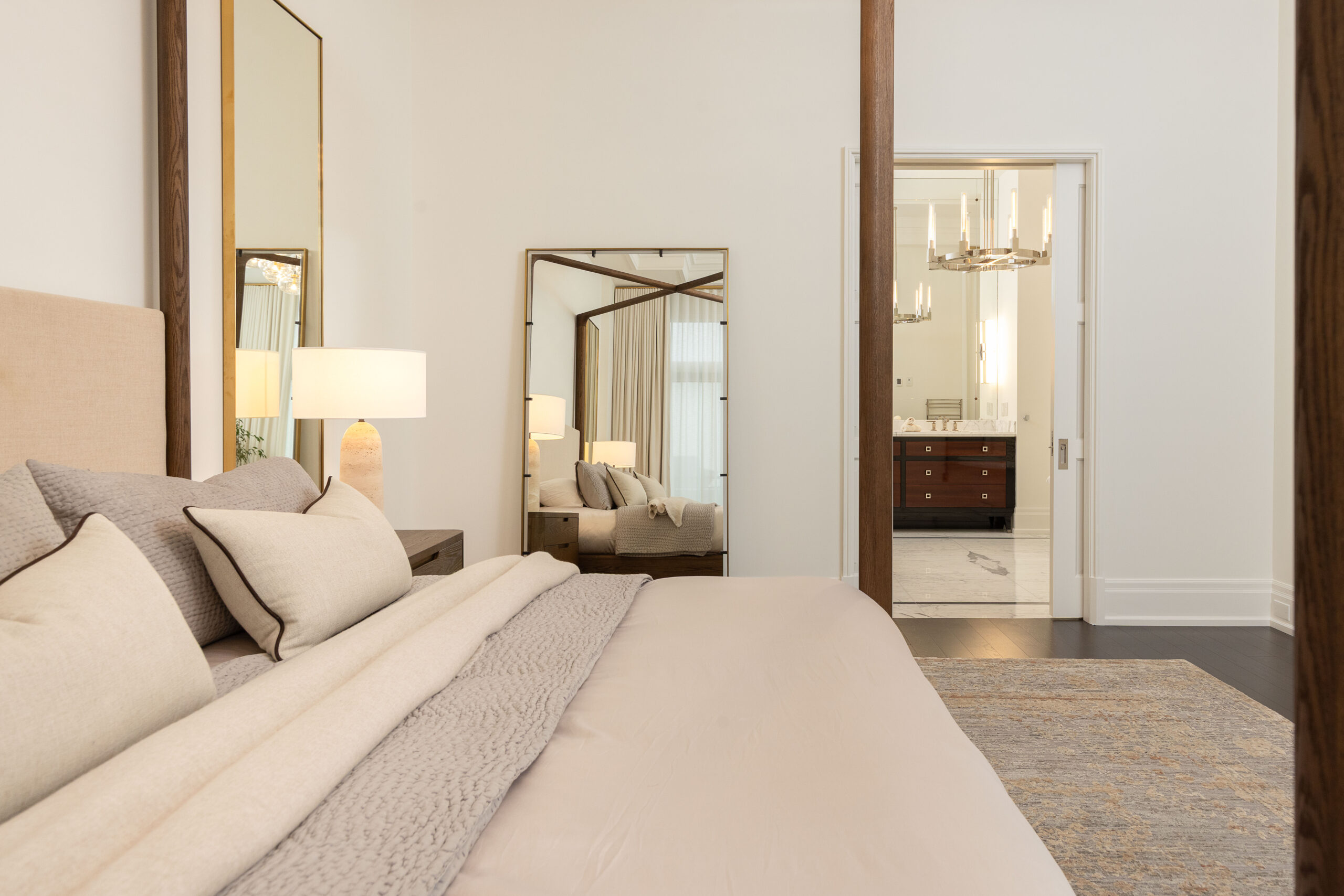 Modern bedroom with a large mirror and adjoining bathroom doorway