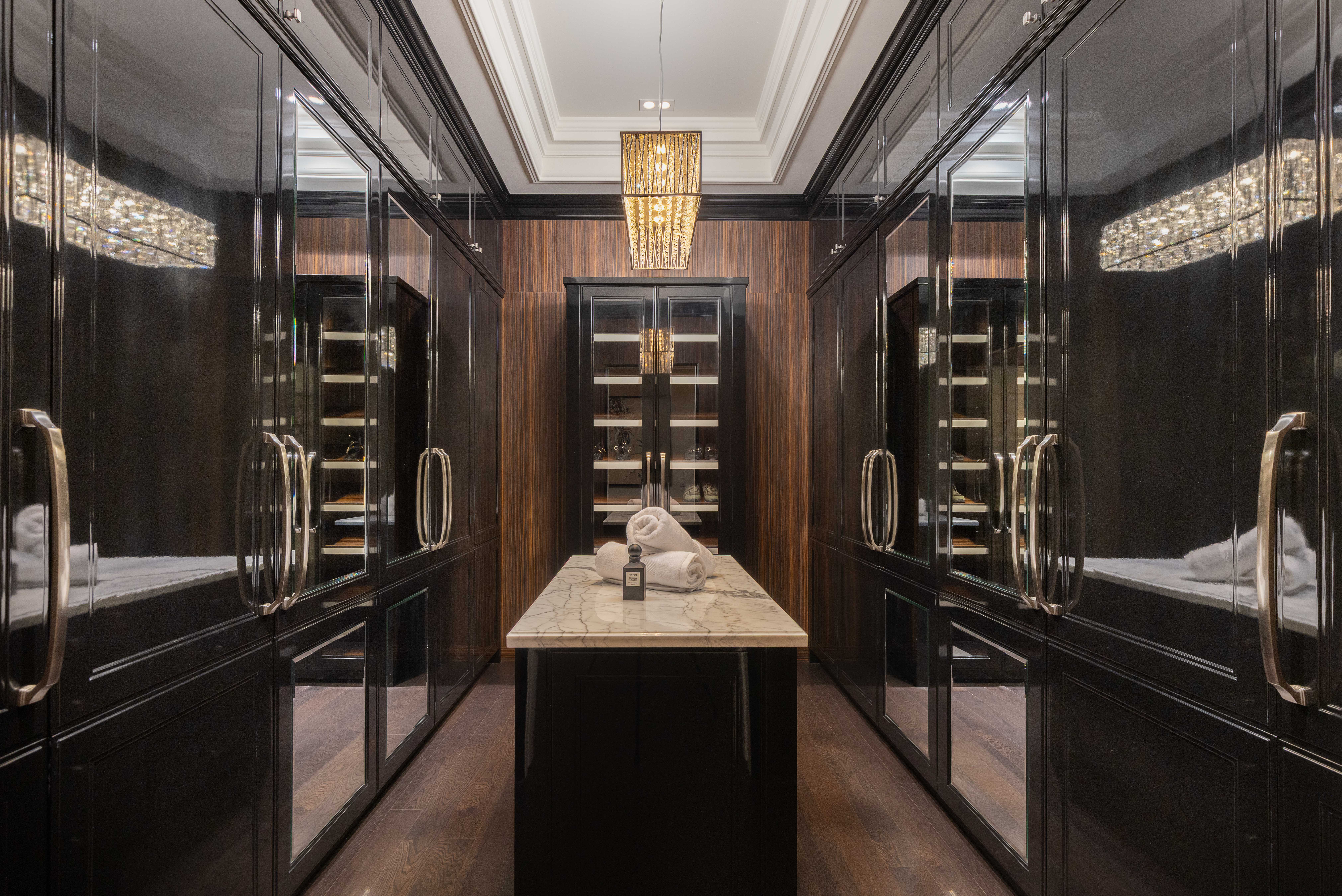 Luxurious walk-in closet with mirrored cabinets and marble island