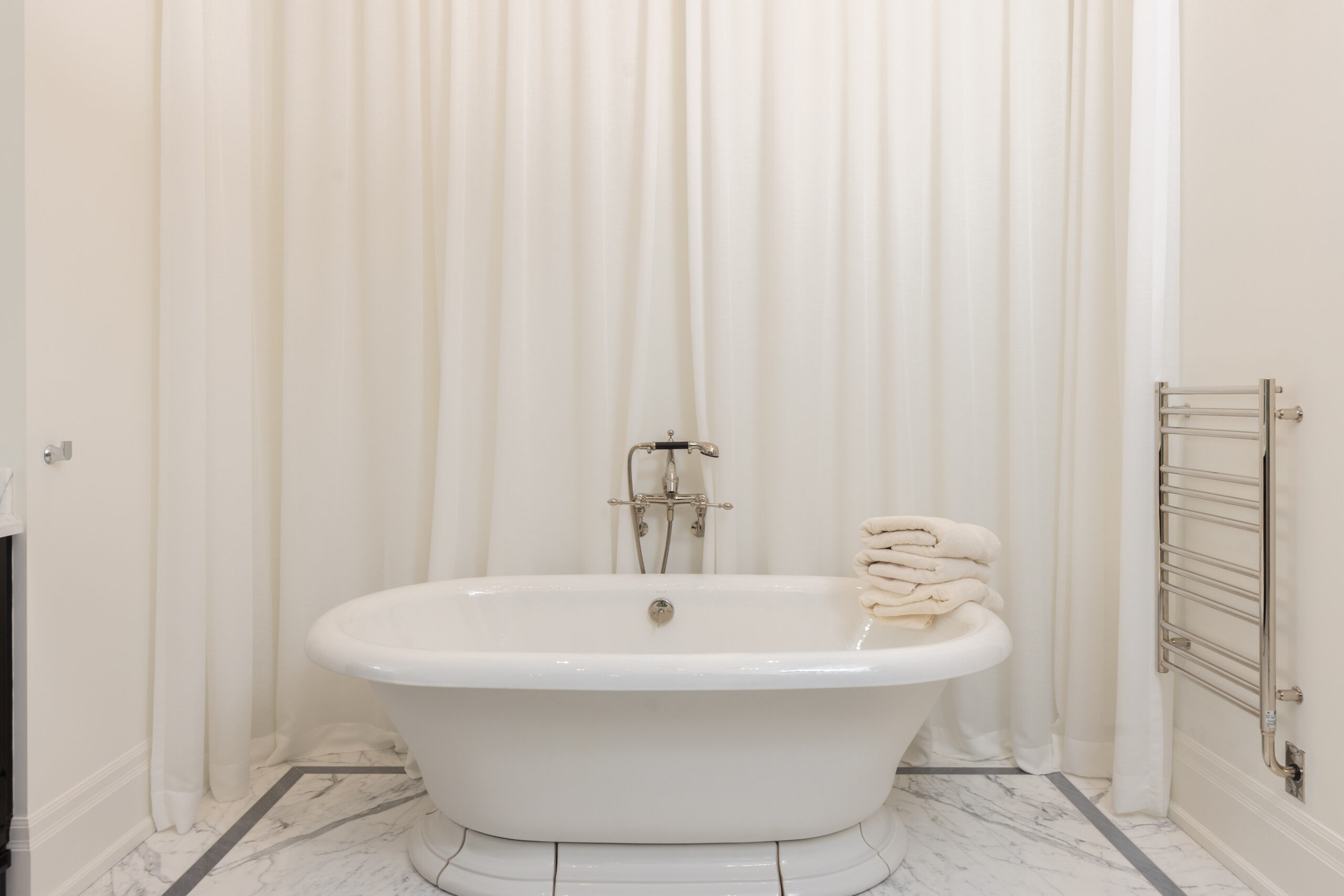 Elegant bathroom featuring a freestanding bathtub and neatly stacked towels
