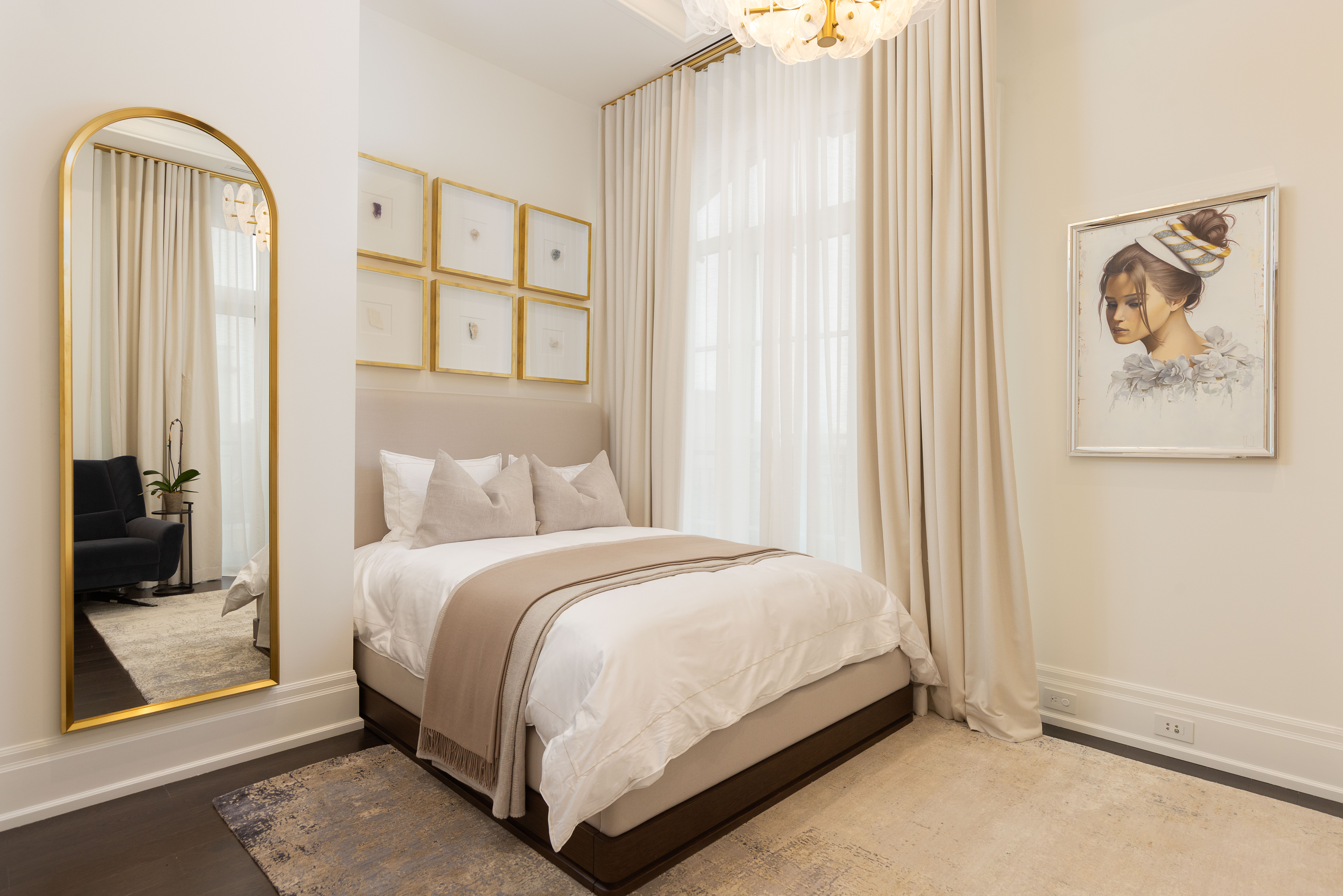 Cozy bedroom with a bed, artwork, and a large mirror