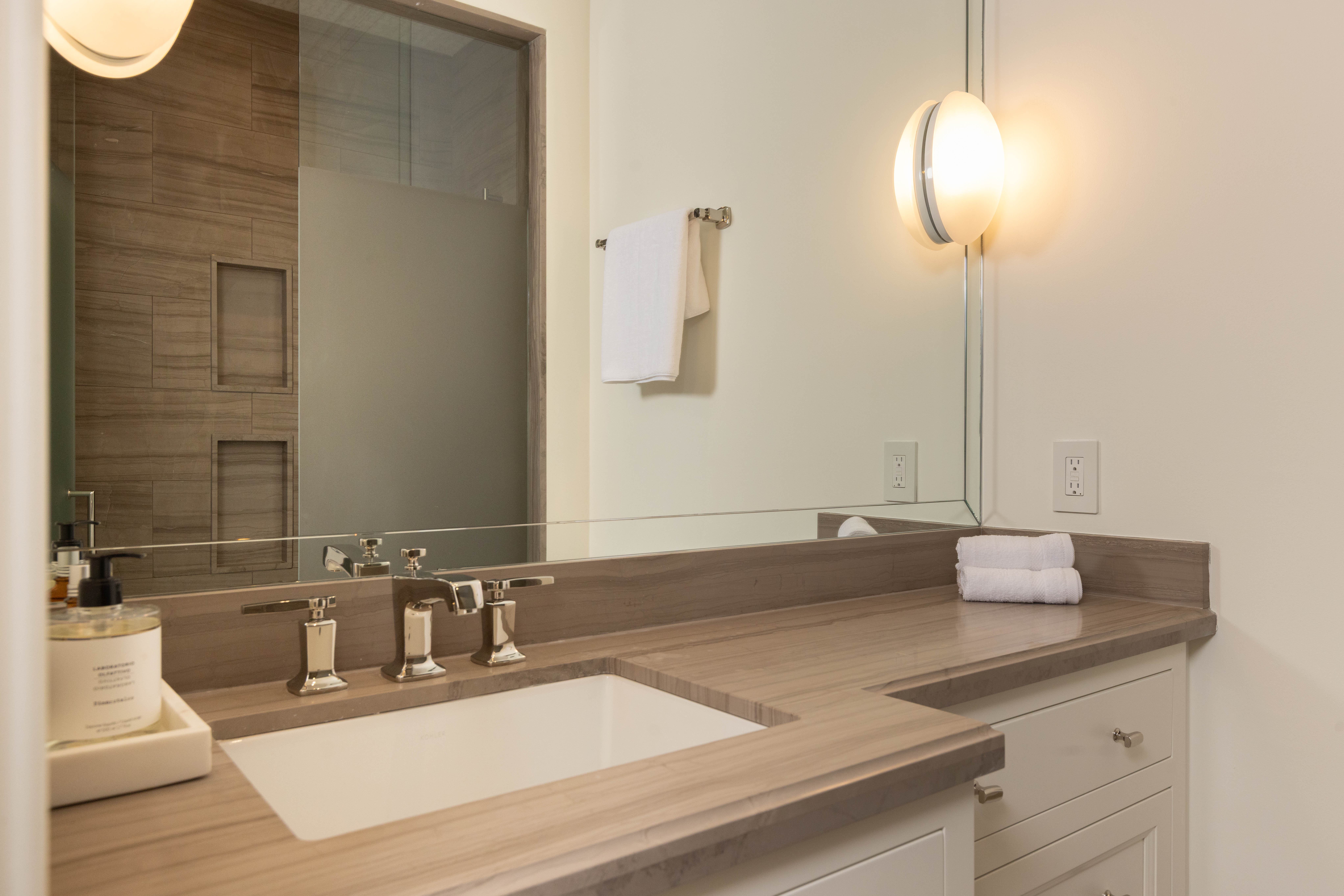 Modern bathroom with a sleek countertop, sink, and stylish lighting