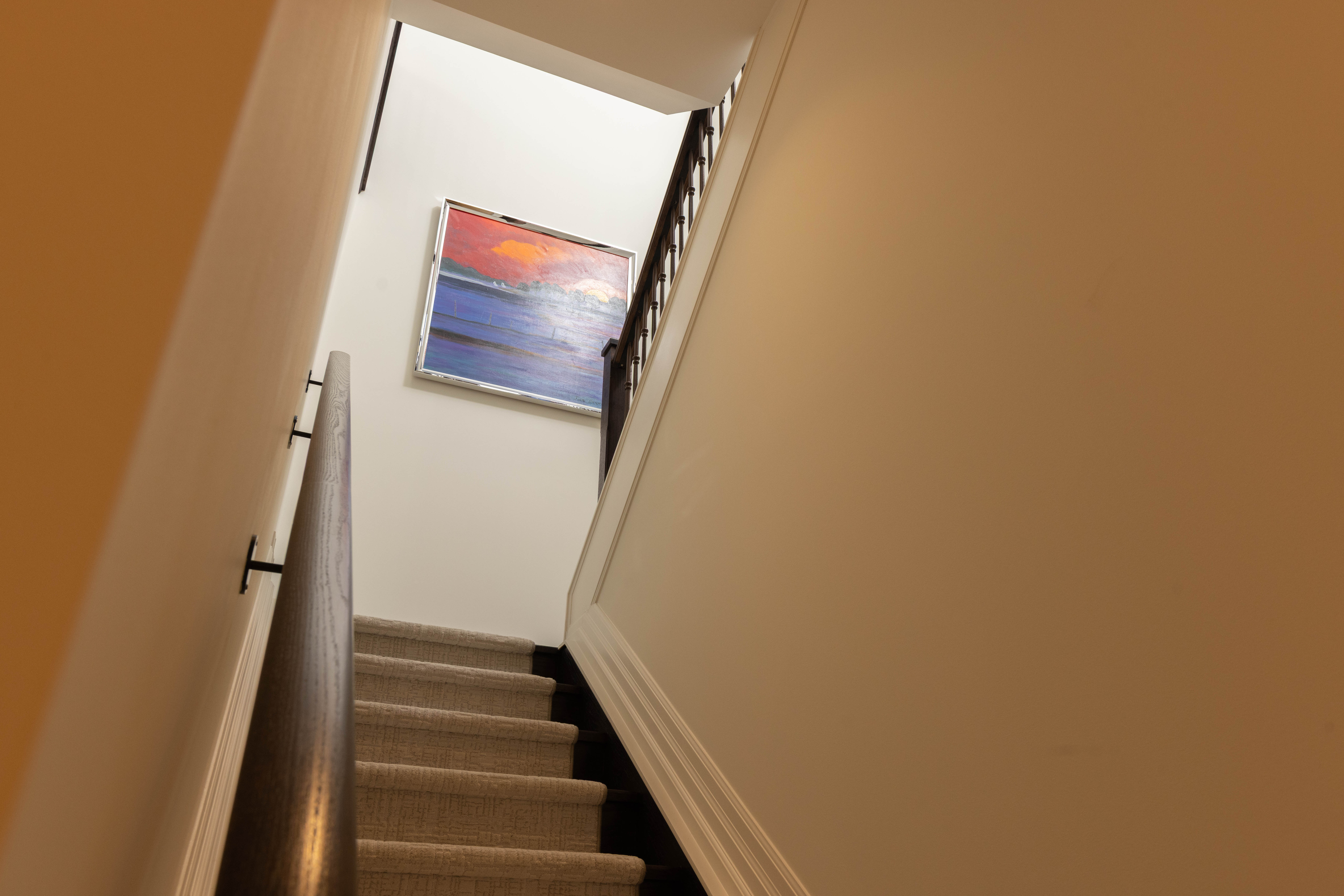 Staircase leading up with a colorful abstract painting on the wall