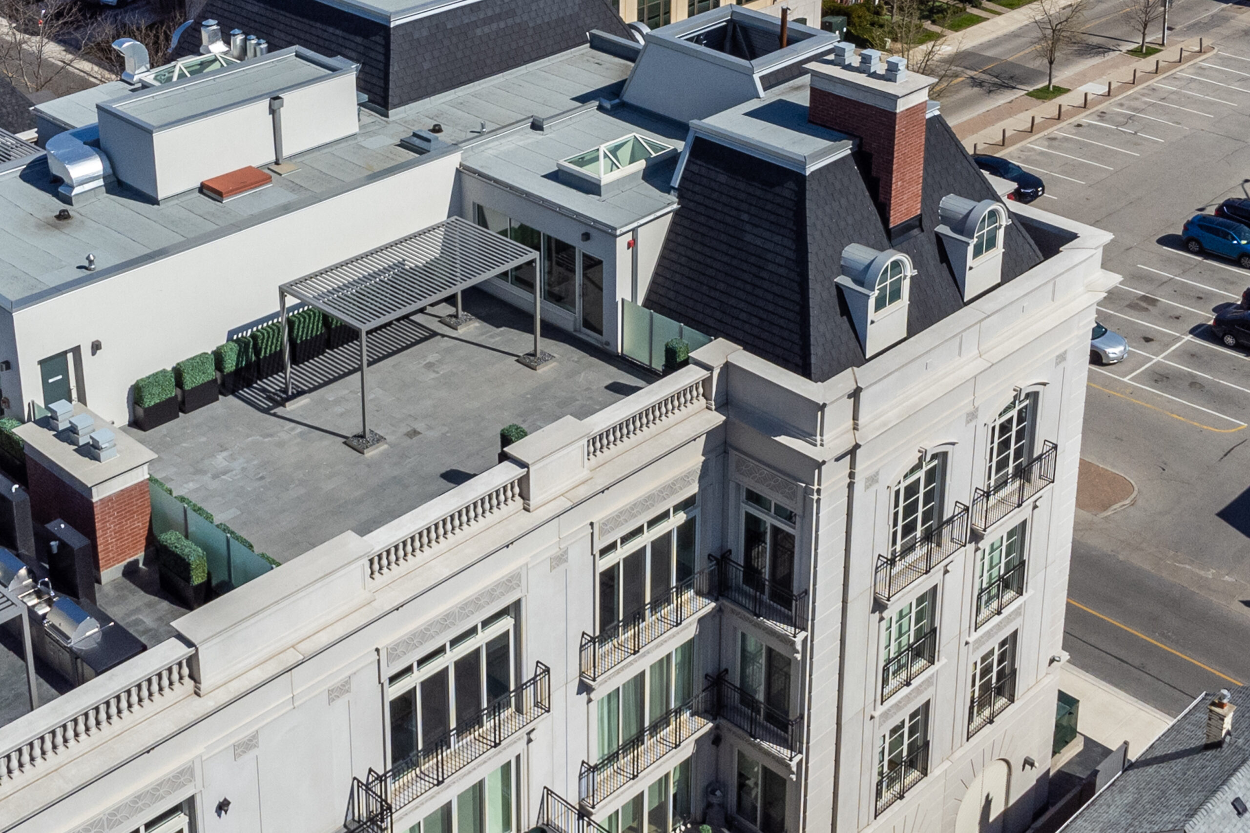 Aerial view of a building rooftop with green accents and urban surroundings
