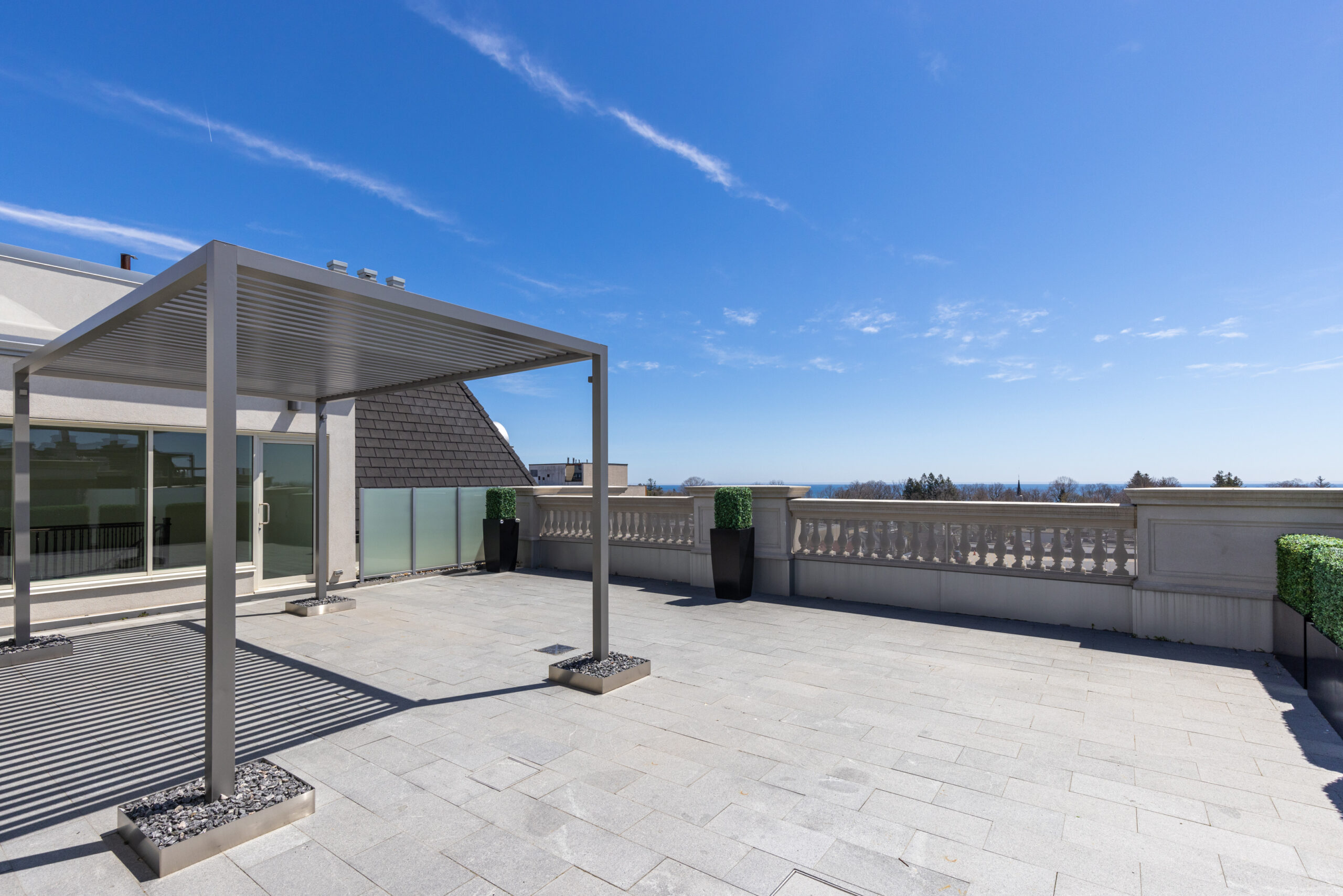 Spacious rooftop terrace with a clear blue sky and distant mountains