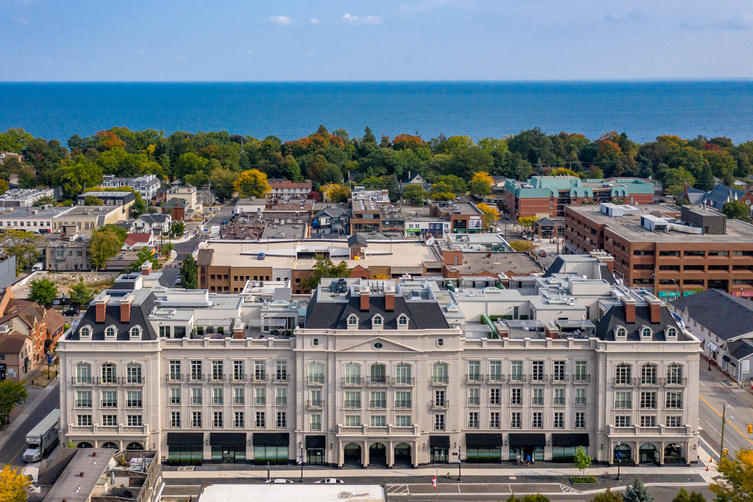 Aerial view of a coastal town with a large building and colorful trees