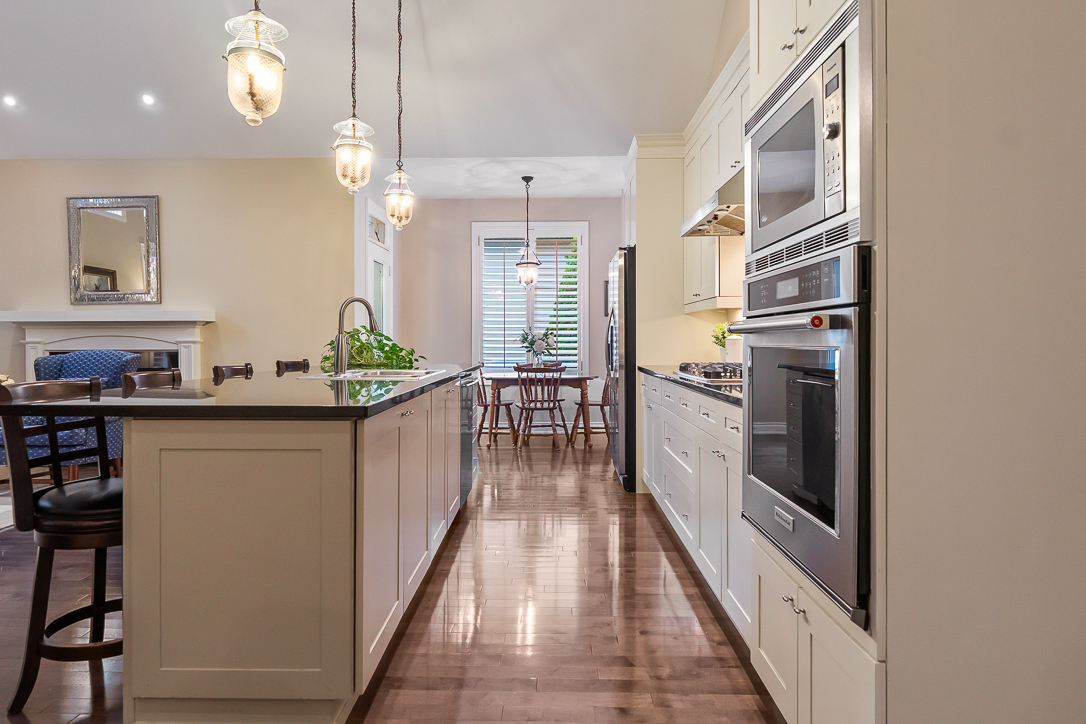 Modern kitchen with wooden floors, island, and pendant lighting