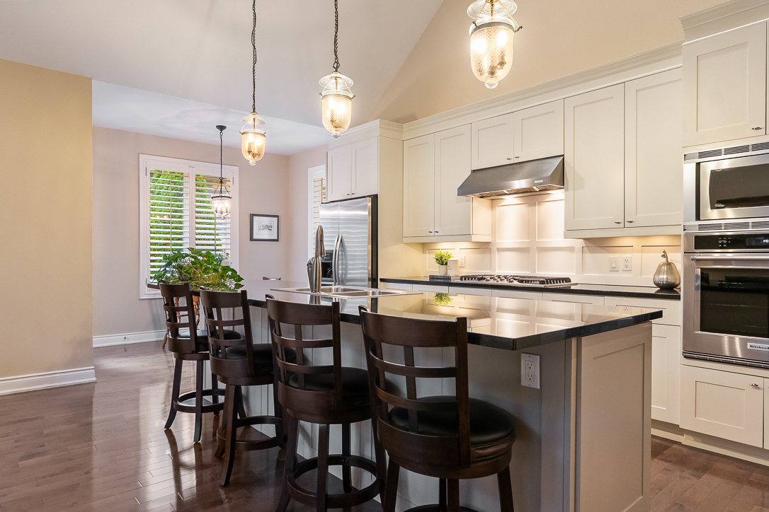 Modern kitchen with white cabinets, dark countertops, and bar seating.