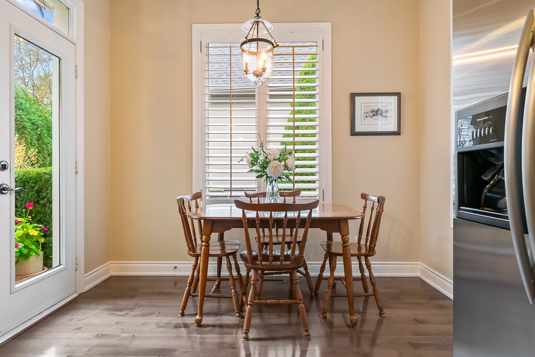 Cozy dining area with wooden table and chairs, natural light from windows