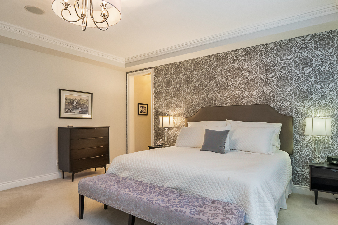 Modern bedroom with a patterned accent wall and stylish furnishings