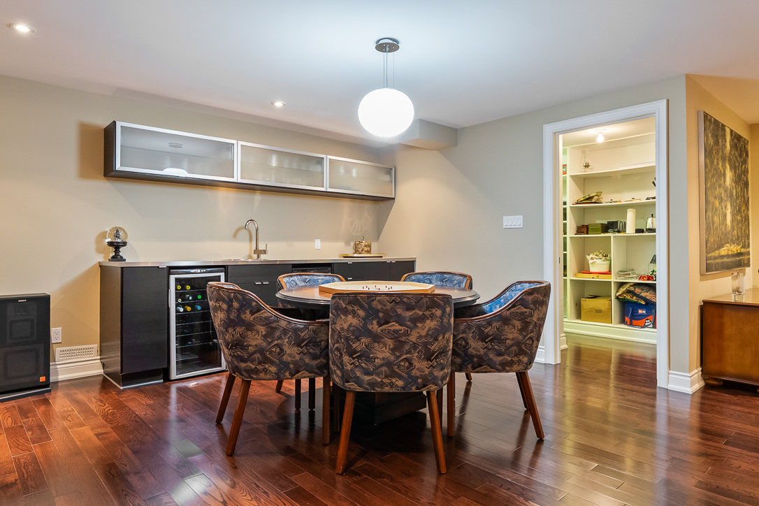 Modern dining area with a round table and stylish chairs, featuring a pantry door.